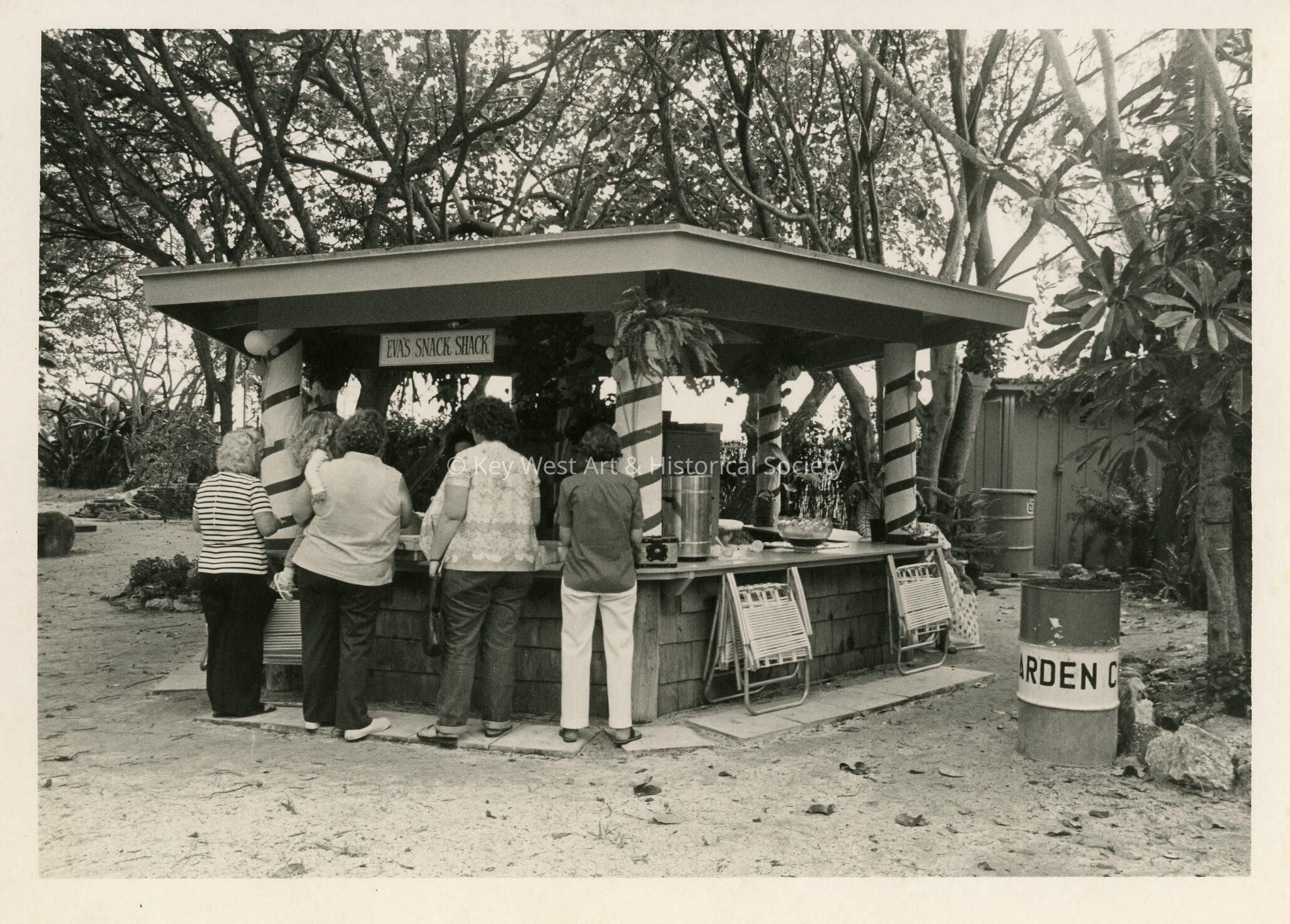 A group of people standing at a snack shack