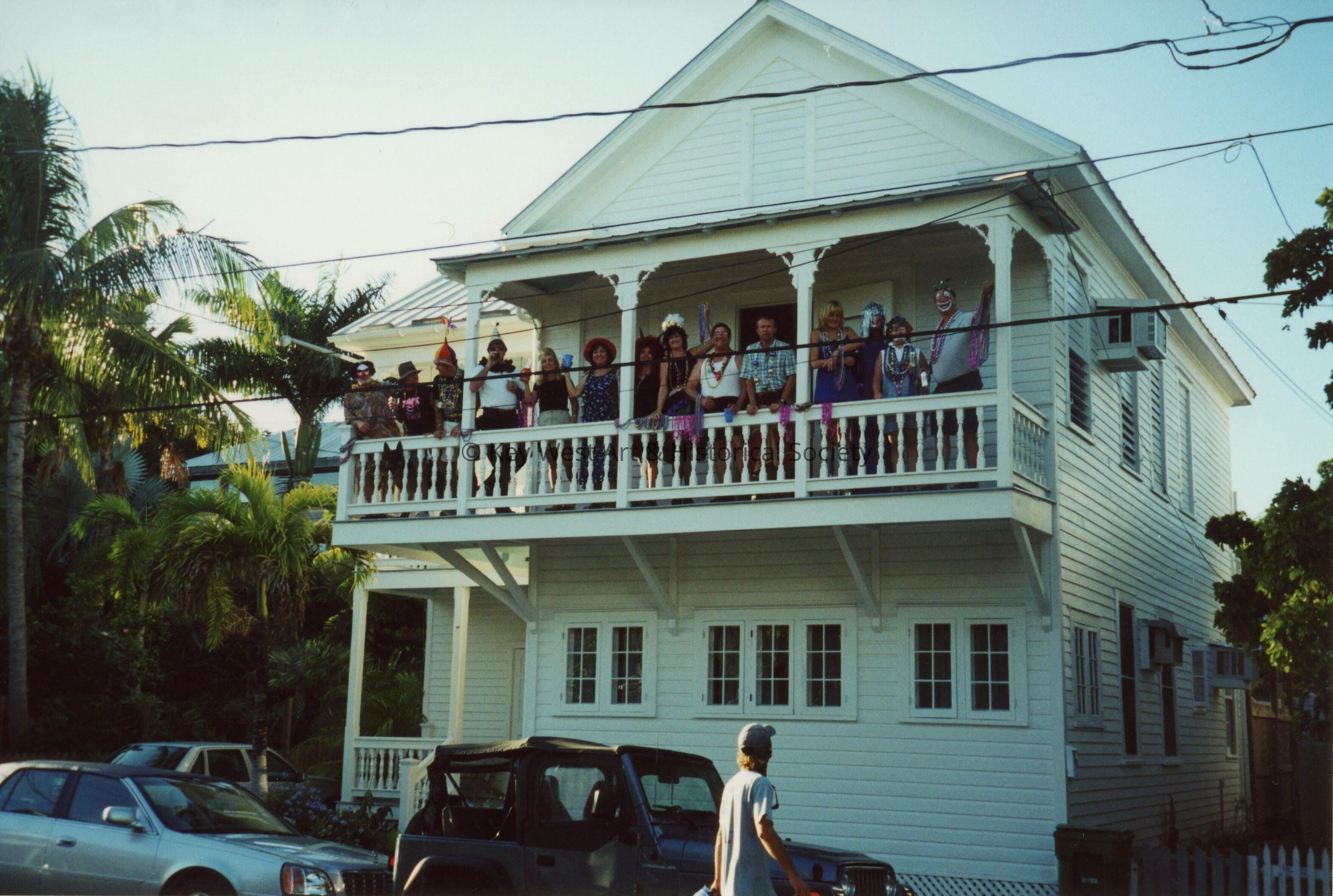 A group of unknown people on the balcony of a building.