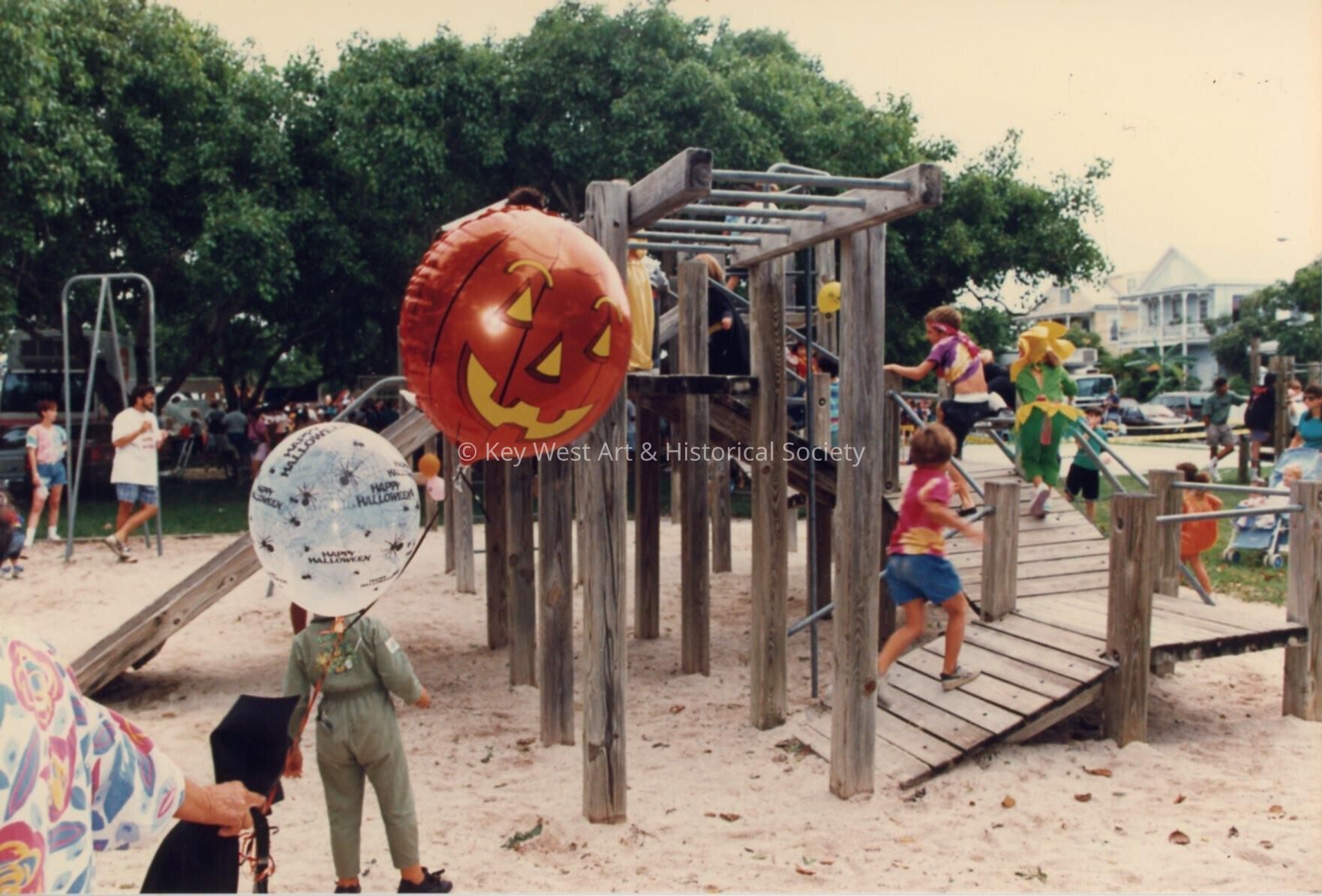 A playground with children that are dressed up playing.