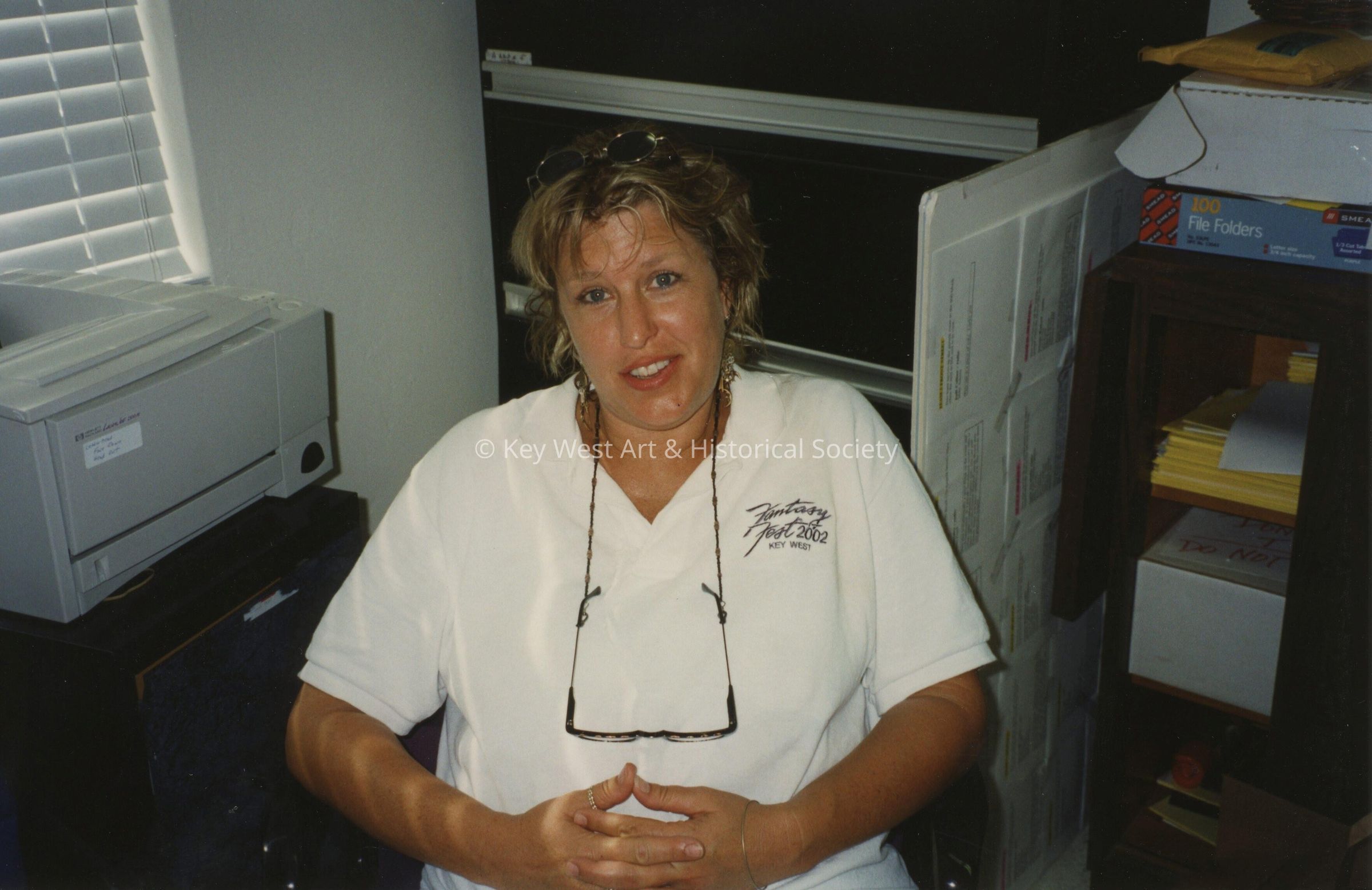 An unknown woman sitting at a desk.