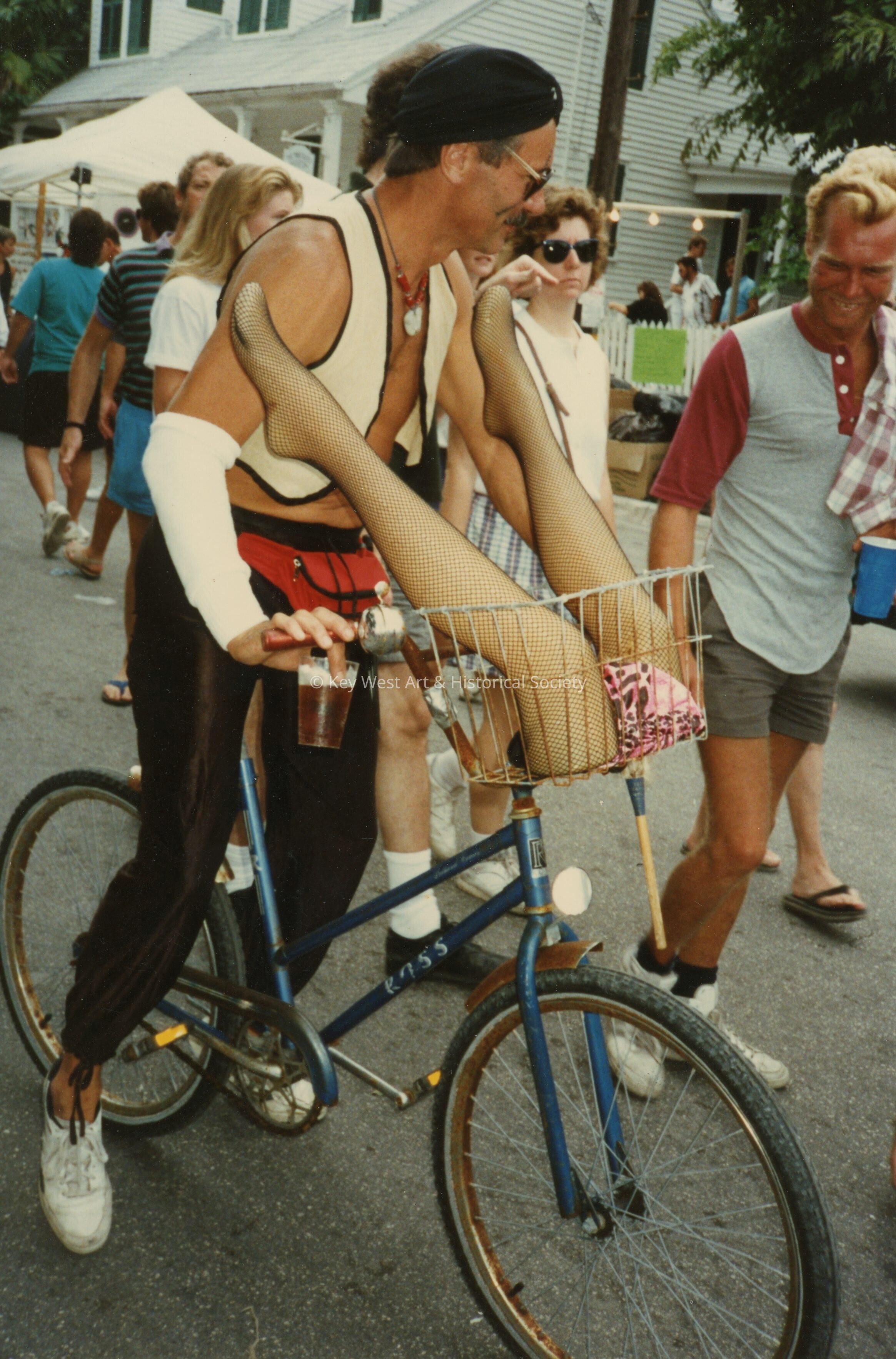 An unknown man dressed up on a bike.