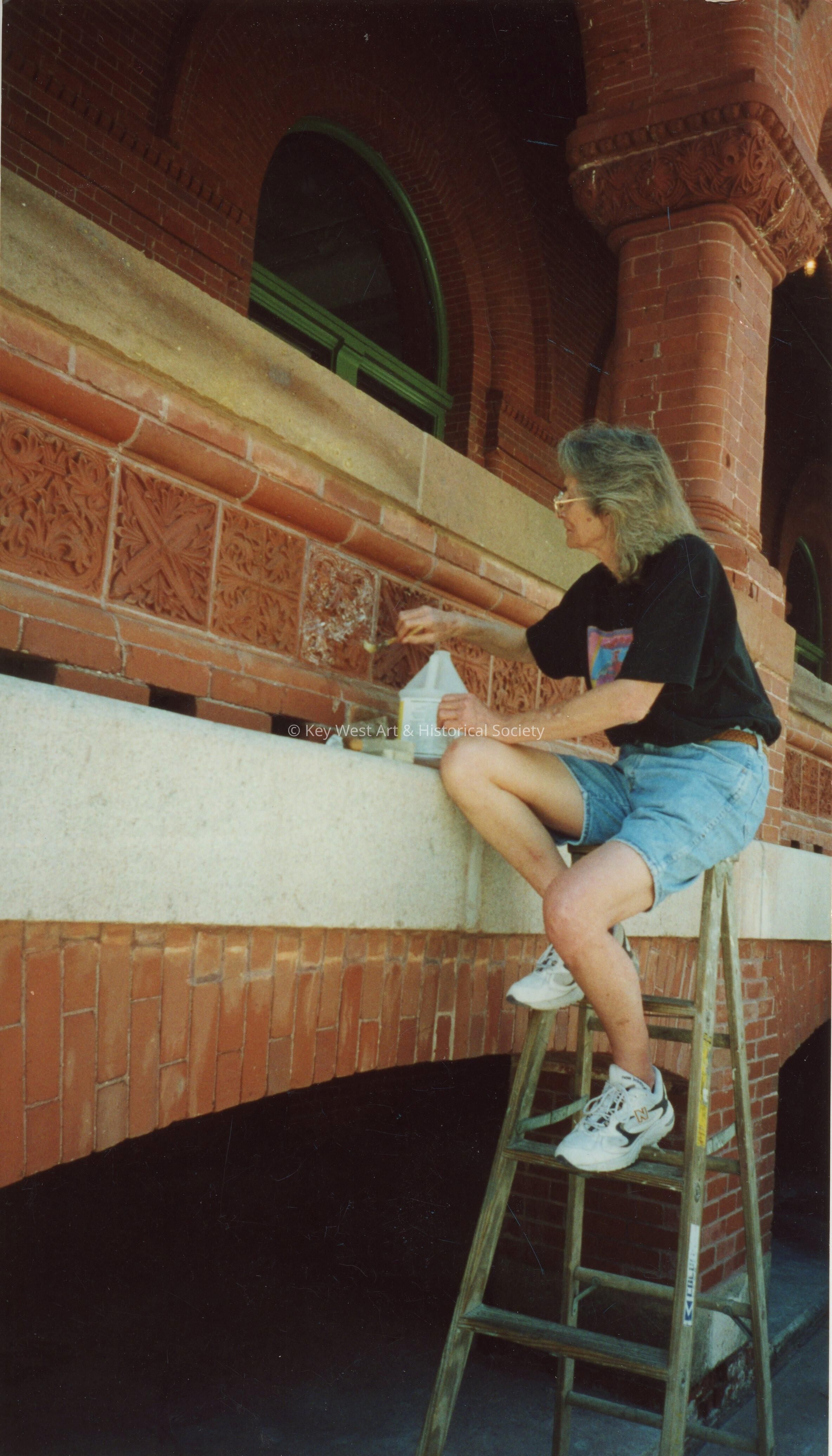 An unknown woman working on the terra cotta detail work.