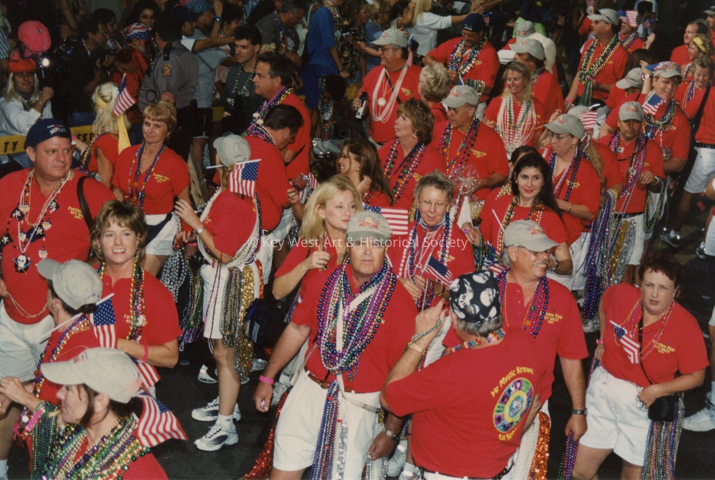 A group on unknown people walking in the street for the parade.