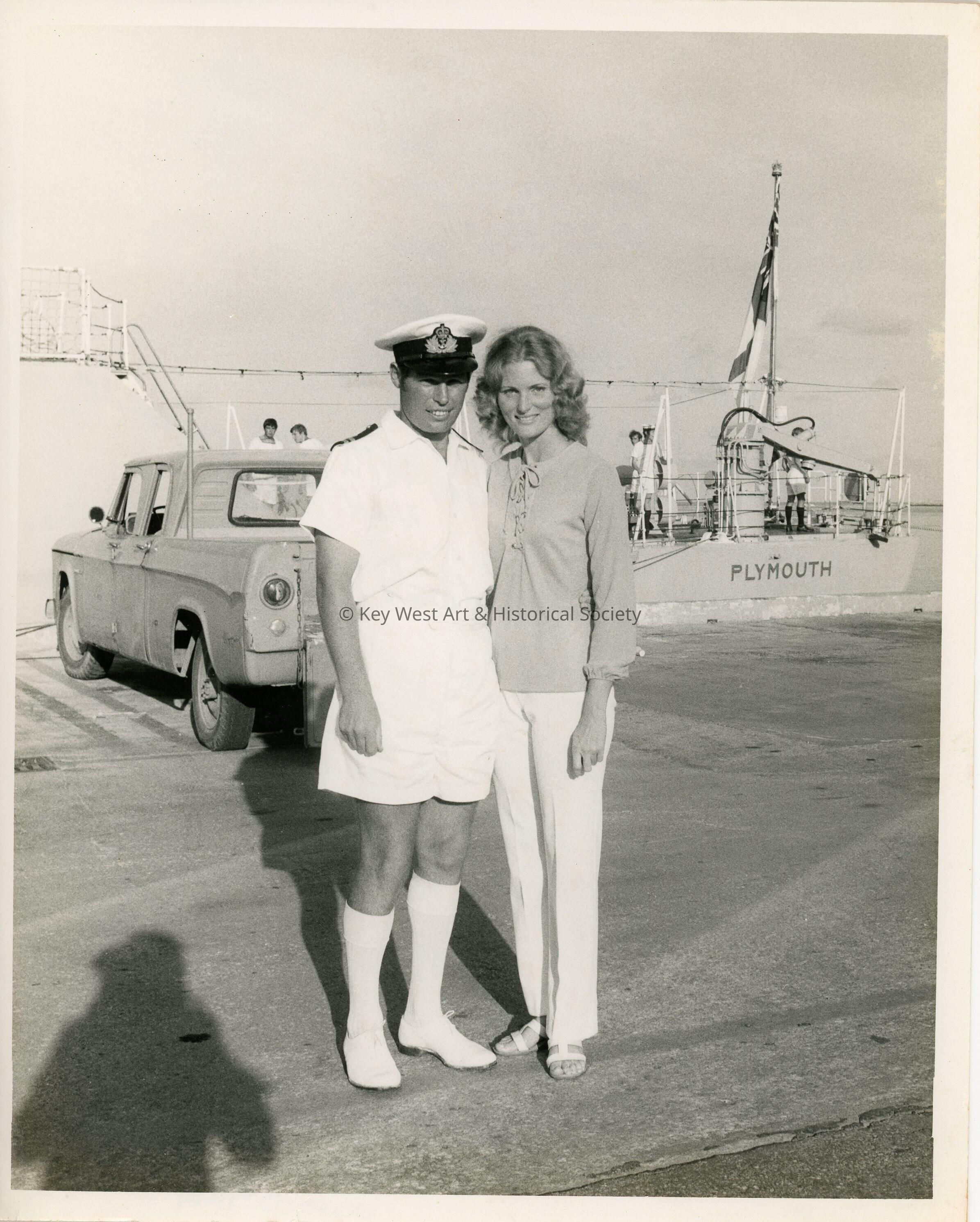 A couple standing outside near a ship