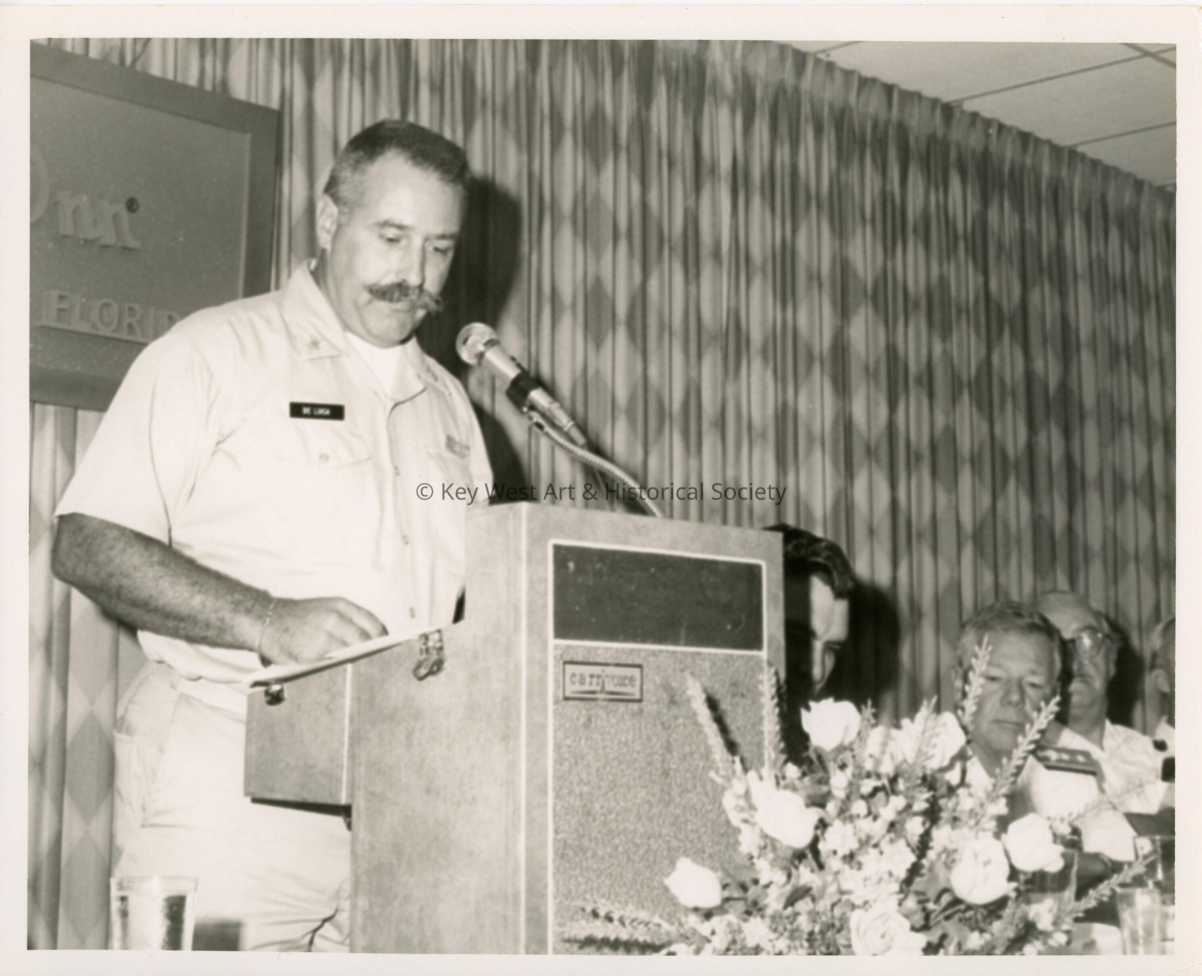 A man in uniform speaking at the podium