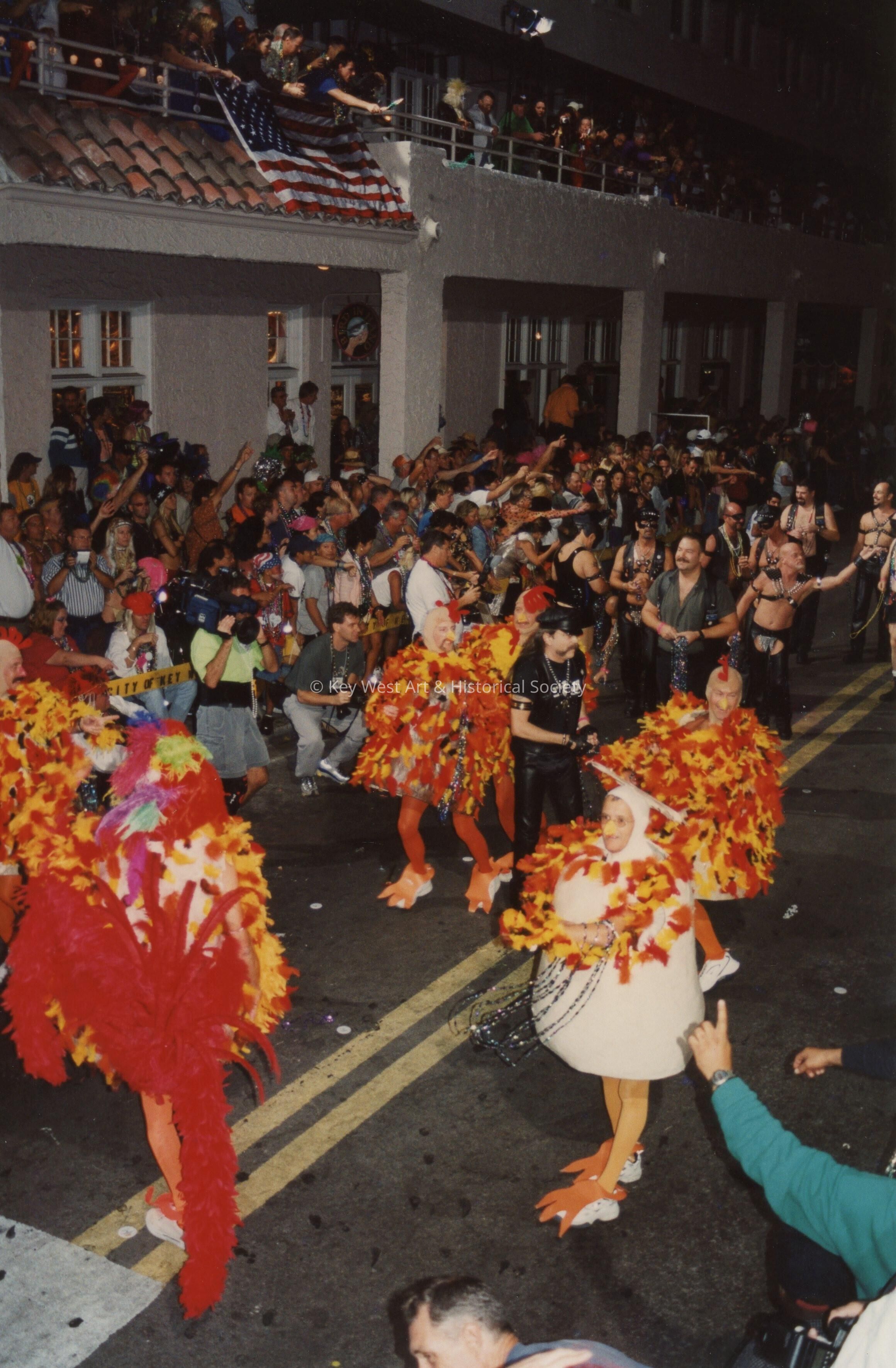 A group of unknown people dressed up walking in the street.