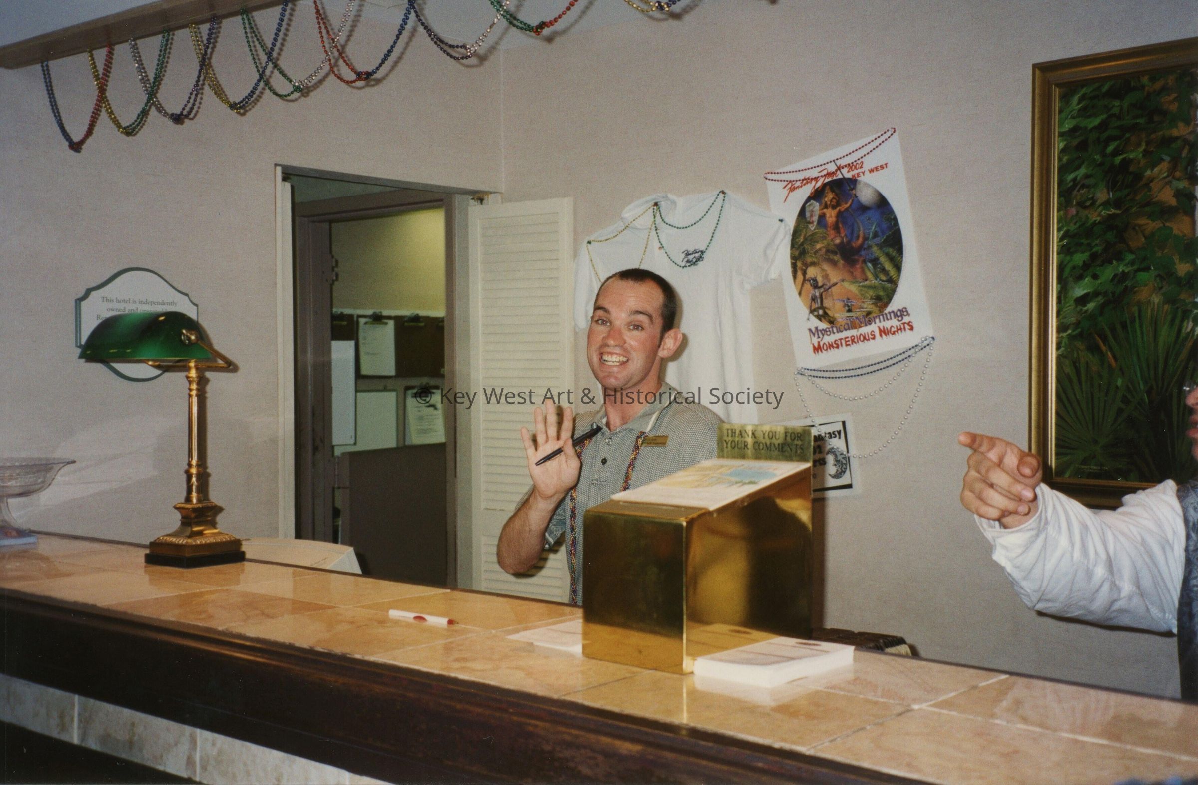 An unknown man standing behind a desk.
