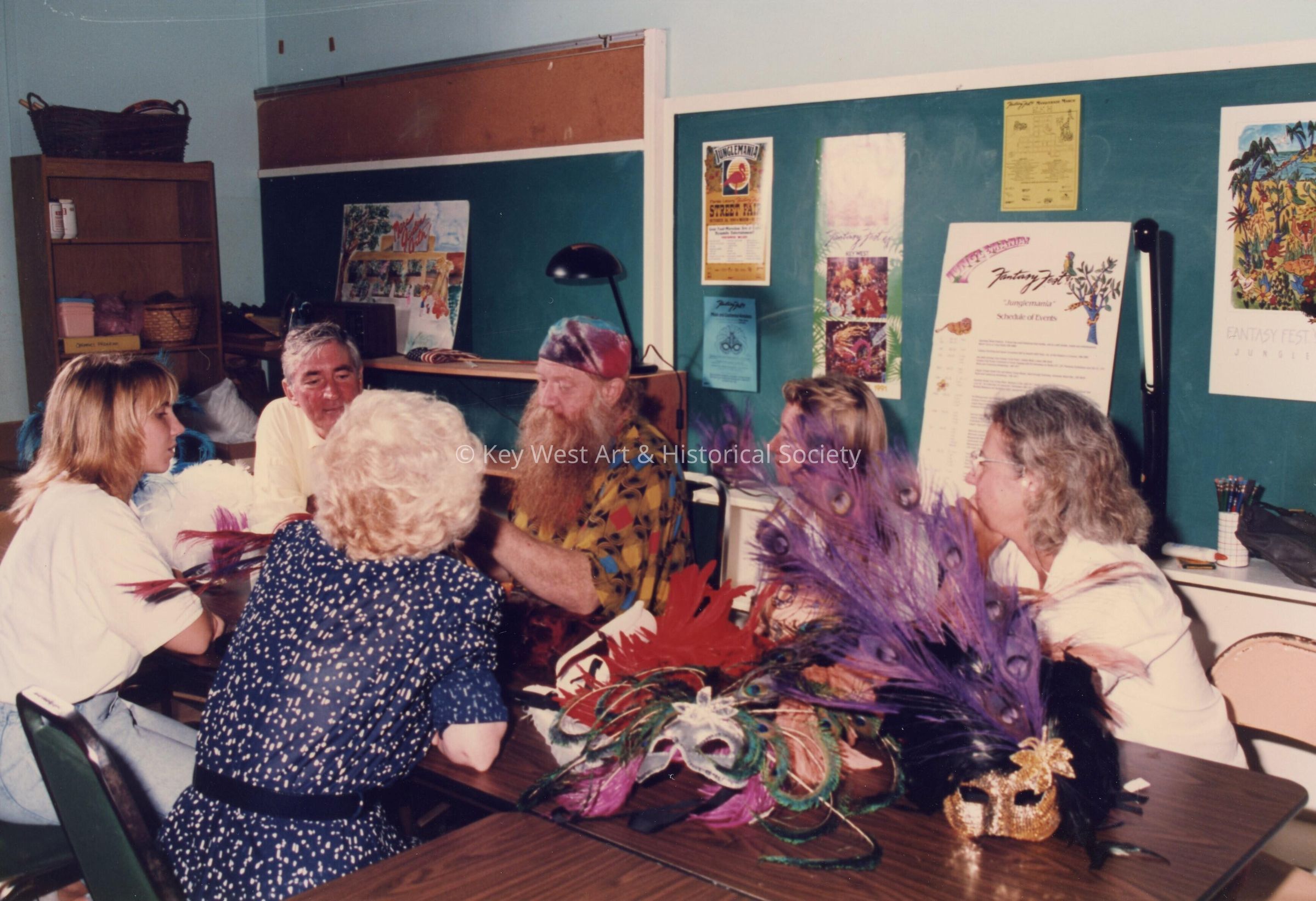 A group of unknown people sitting at a table talking.
