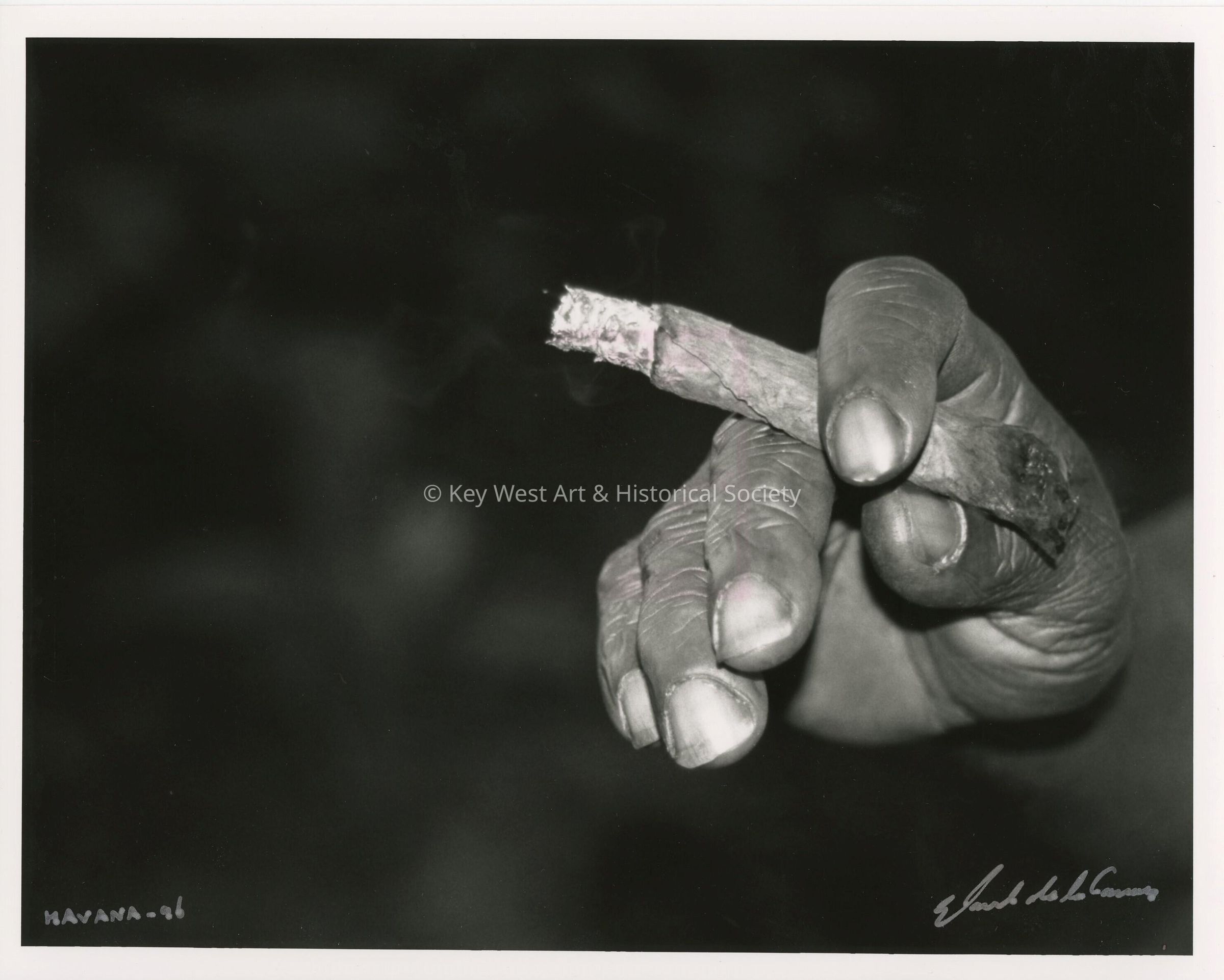 A mans hand holding a cigar