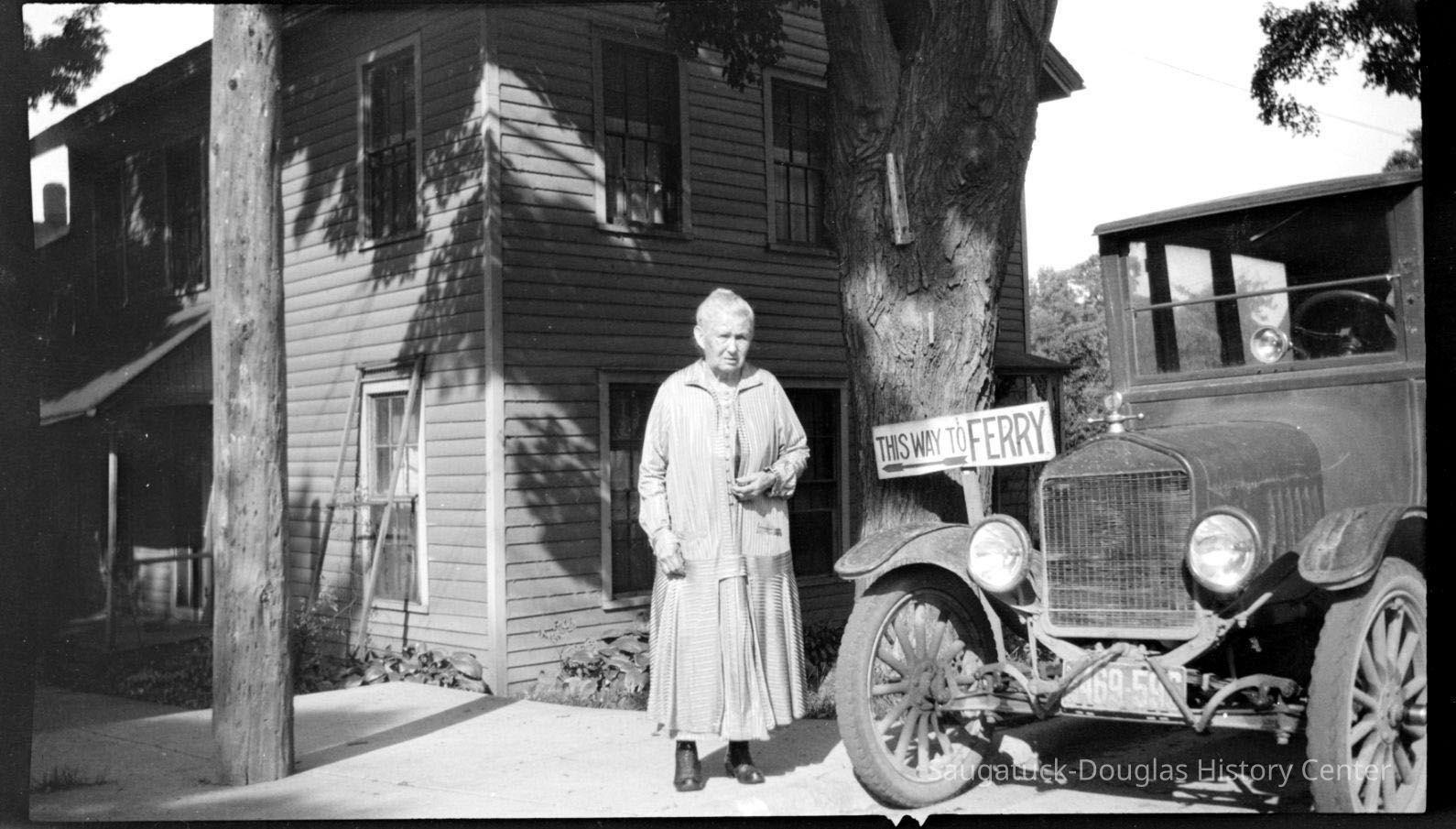 hmbButler&MaryBillingsWoman.jpg 280KB; ca 1910. The photo depicts a mature woman standing next to a model T style car and a sign that says