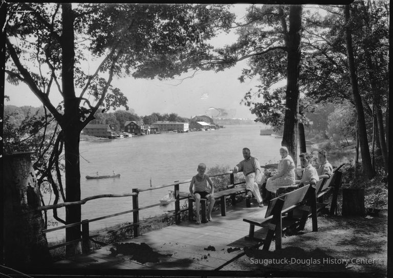         95 84 20 No. Park St. view.jpg 1.1MB; Box 31, envelope 95-84-20 
A mature man and woman, two young men and a boy sit on benches along the west bank of river, downstream from the chain ferry crossing. The Big Pavilion, Hotel Mt. Baldhead and a pair of people in a canoe are visible in the background.
   