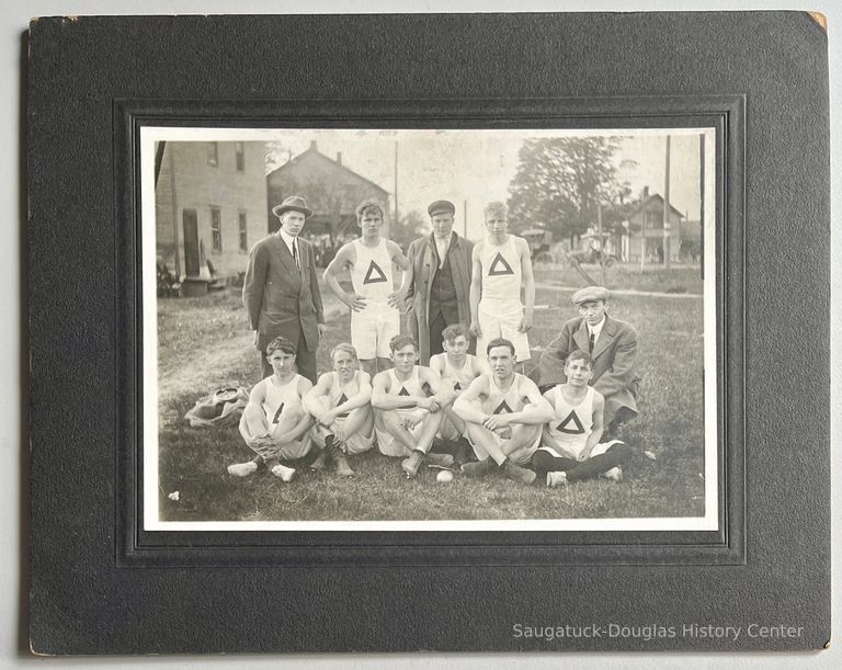          Wearing street clothing and between the two standing athletes is Dick Newnham.
   