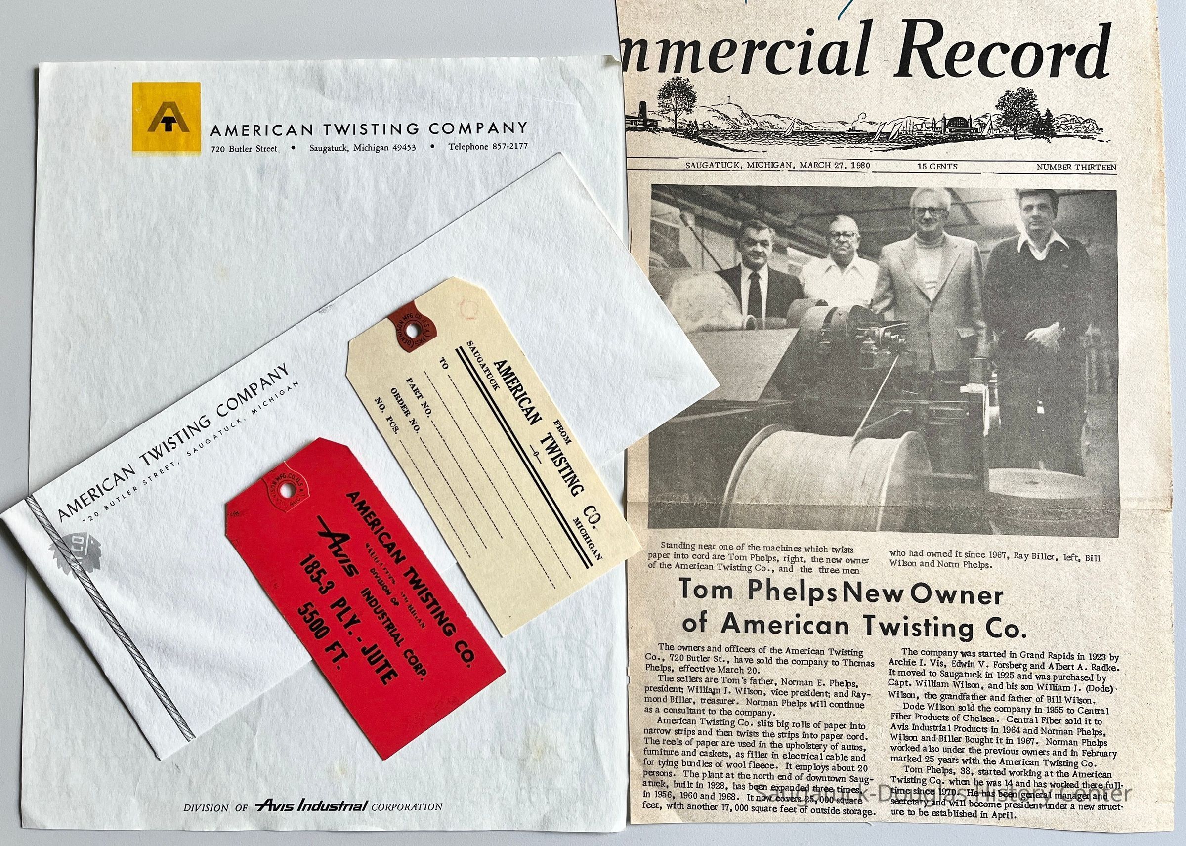 Standing near one of the machines which twists paper into cord are Tom Phelps, right, the new owner of the American Twisting Co., and the three men who had owned it since 1967, Ray Biller, left, Bill Wilson and Norm Phelps.
The owners and officers of the American Twisting Co., 720 Butler St., have sold the company to Themas Phelps, effective March 20.
The sellers are Tom's father, Norman E. Phelps, president; William J. Wilson, vice president; and Raymond Biller, treasurer. Norman Phelps will continue as a consultant to the company.
American Twisting Co. slits big rolls of paper into narrow strips and then twists the strips into paper cord. The reels of paper are used in the upholstery of autos, furniture and caskets, as filler in electrical cable and for tying bundles of wool fleece. It employs about 20 persons. The plant at the north end of downtown Saugatuck, built in 1928, has been expanded three times, in 1956, 1960 and 1968. It now covers 25, 000 square feet, with another 17, 000 square feet of outside storage.
The company was started in Grand Rapids in 1923 by Archie I. Vis, Edwin V. Forsberg and Albert A. Radke.
It moved to Saugatuck in 1925 and was purchased by Capt. William Wilson, and his son William J. (Dode) Wilson, the grandfather and father of Bill Wilson, Dode Wilson sold the company in 1955 to Central Fiber Products of Chelsea. Central Fiber sold it to Avis Industrial Products in 1964 and Norman Phelps, Wilson and Biller Bought it in 1967. Norman Phelps worked also under the previous owners and in February marked 25 years with the American Twisting Co.
Tom Phelps, 38, started working at the American Twisting Co. when he was 14 and has worked there full-time since 1970. He has been general manager and secretary and will become president under a new structure to be established in April.