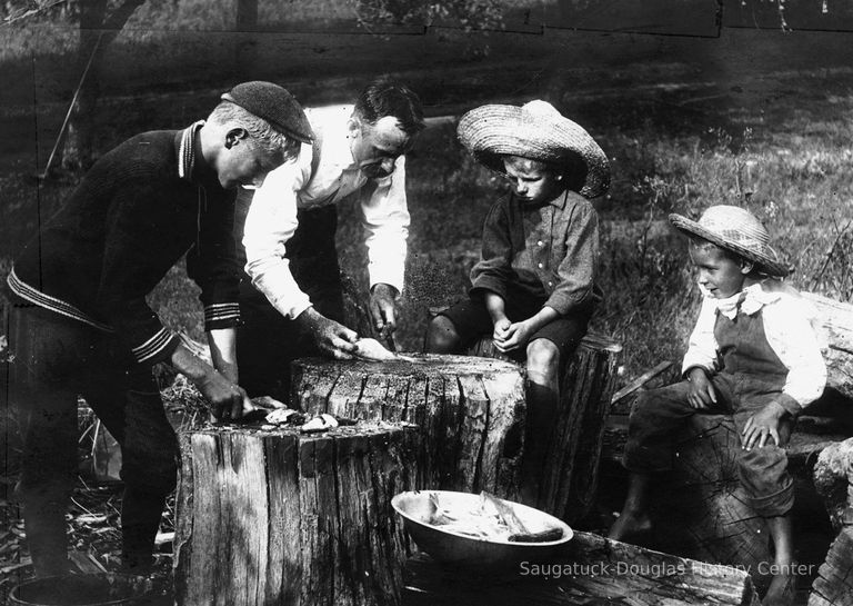          file800.jpg 2.5MB; A man and three boys cleaning fish on a stump
   