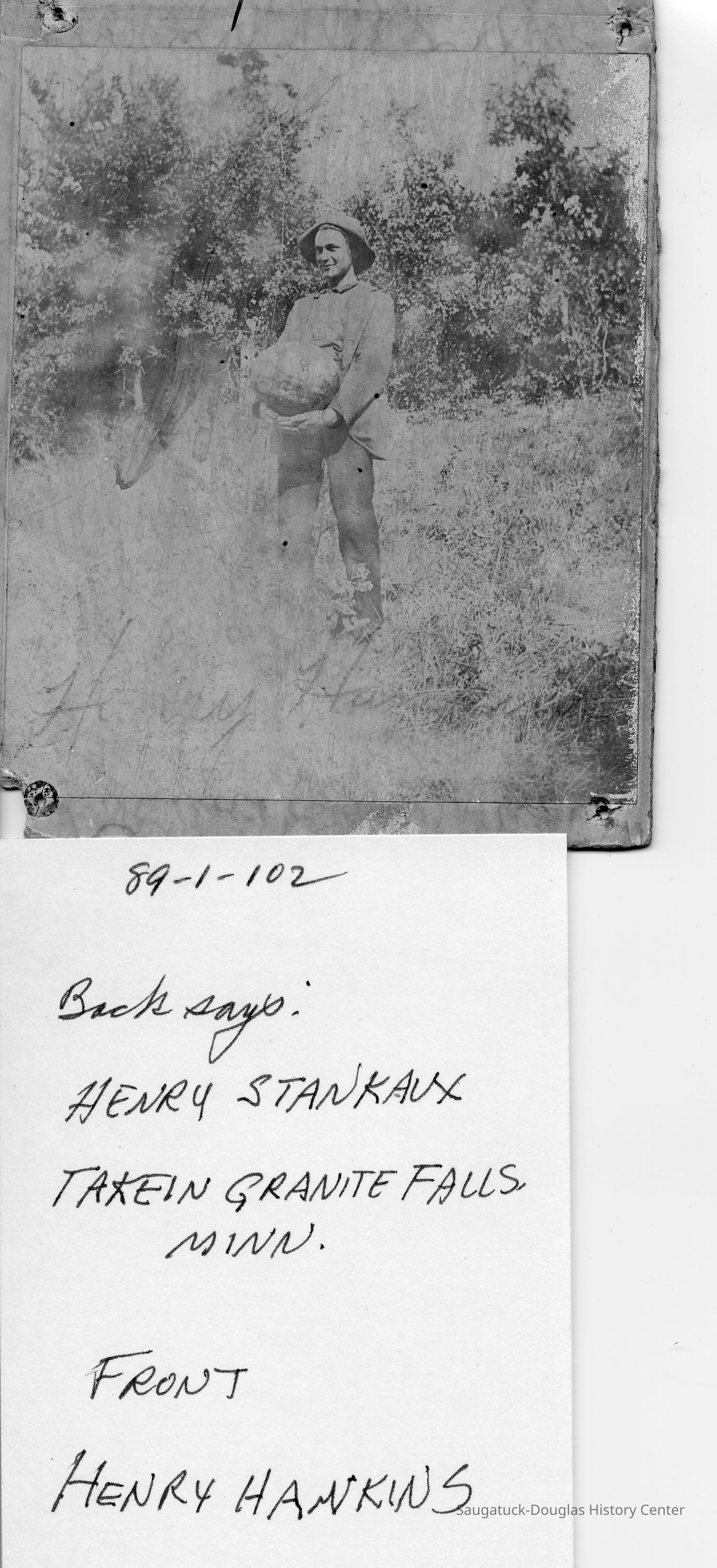         89-1-102_Henry_Hankins.jpg 593KB; Back says Henry Stankaux takein Granite Falls, Minn. Front Henry Hawkins or Hankins - a young man holding a watermelon or a very round rock.
   