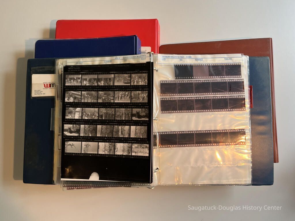 Photos of four binders that were consolidated into three for the archive