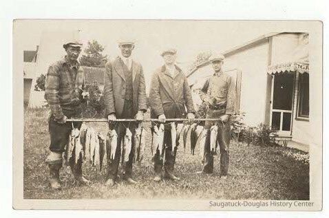          Men holding up fish on line
   