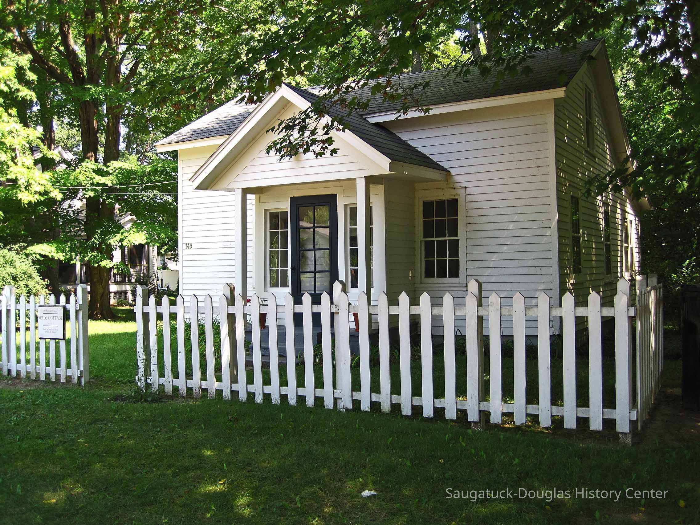 Wade.jpg 539KB; photo from 2011 SDHS Heritage Home Tours with text:
Wade Cottage (1851), 149 Washington Street.
Douglas’s first house. Built by Jonathan Wade, founder of Douglas (then called Dudleyville), this is a traditional two-room up and two-room down settler’s house, with a “lean-to” dining/kitchen addition and pedimented front porch added in the 1920s. Original vertical “plank” construction can be observed from the interior. Currently used as the shared part time country home of artist & designers.