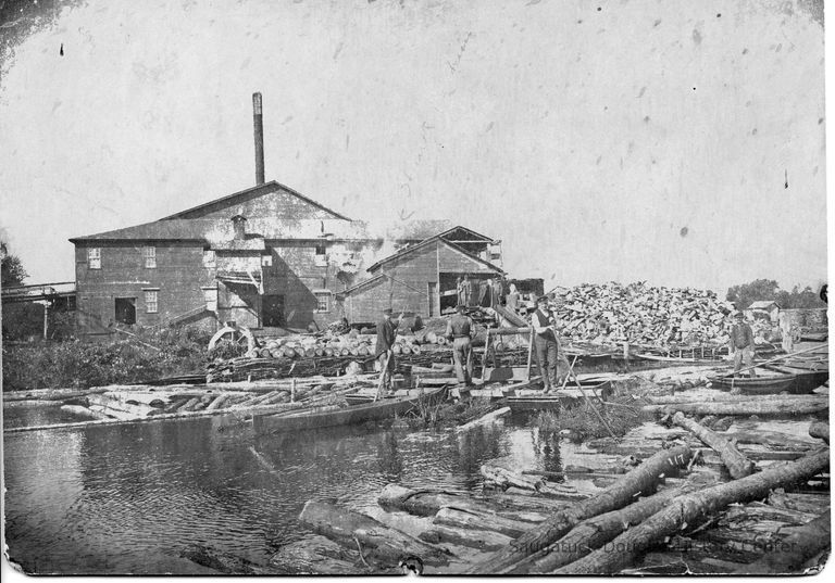          89-1-65_B_Basket_factory.jpg 1.2MB; 89-1-65 workers guiding logs from the boom into the sawmill
   