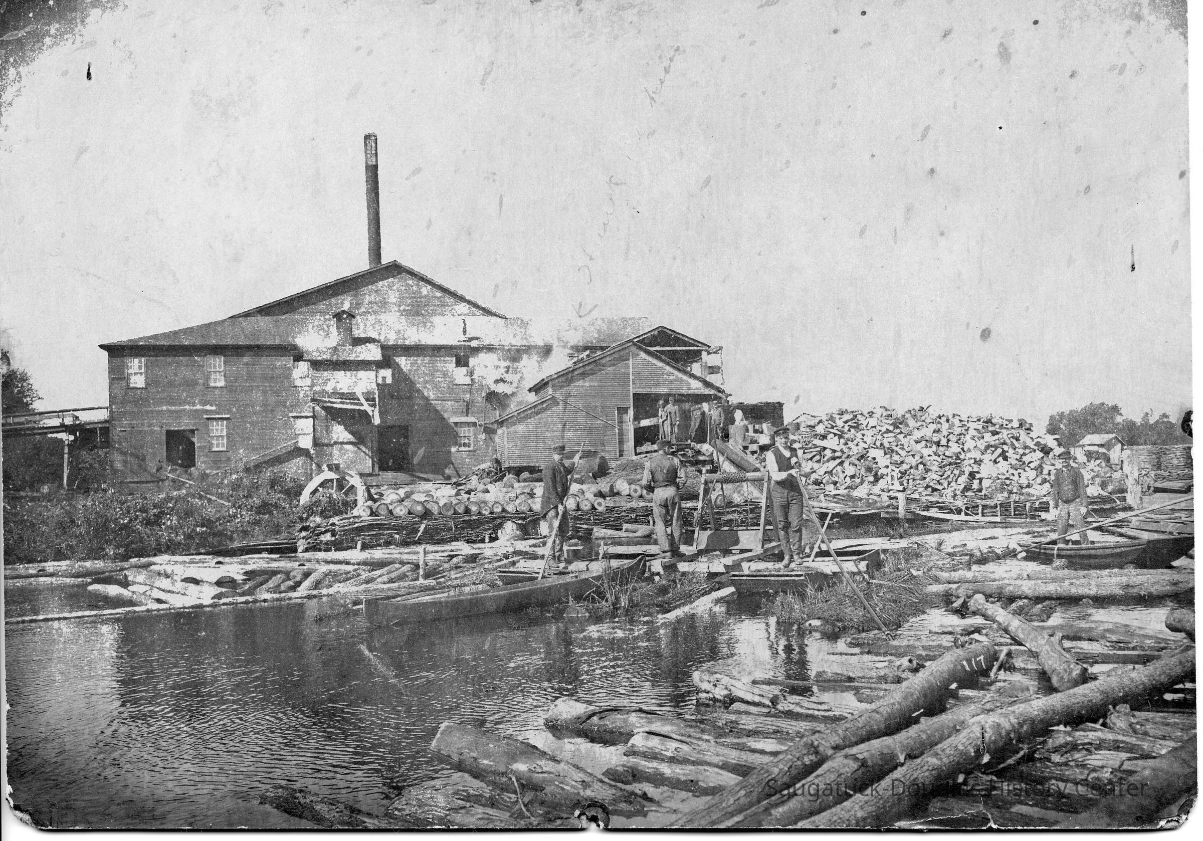 89-1-65_B_Basket_factory.jpg 1.2MB; 89-1-65 workers guiding logs from the boom into the sawmill