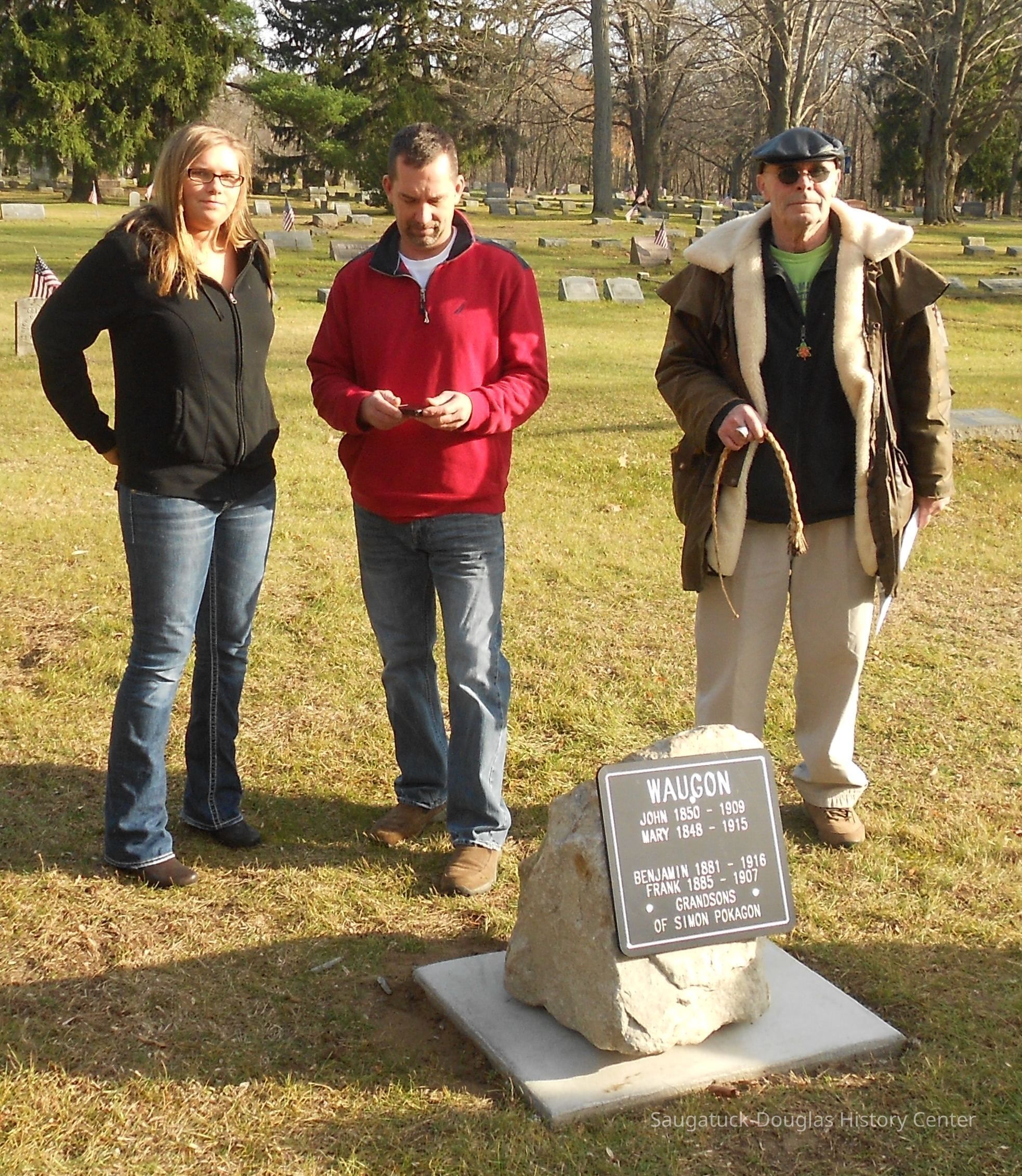          image003.jpg 949KB -- Courtney, Joe and Tom Shashagway; 100 Years Late
Pokagon Family Gets Riverside Memorial

Family and Others Gather
About thirty people gathered at Saugatuck's Riverside Cemetery the day after Thanksgiving to unveil a memorial on the previously unmarked plot of two grandsons of the famous Pottawatomi leader Simon Pokagon. Exactly one year earlier, a group of volunteers had been there to plant daffodils on the graves of various 