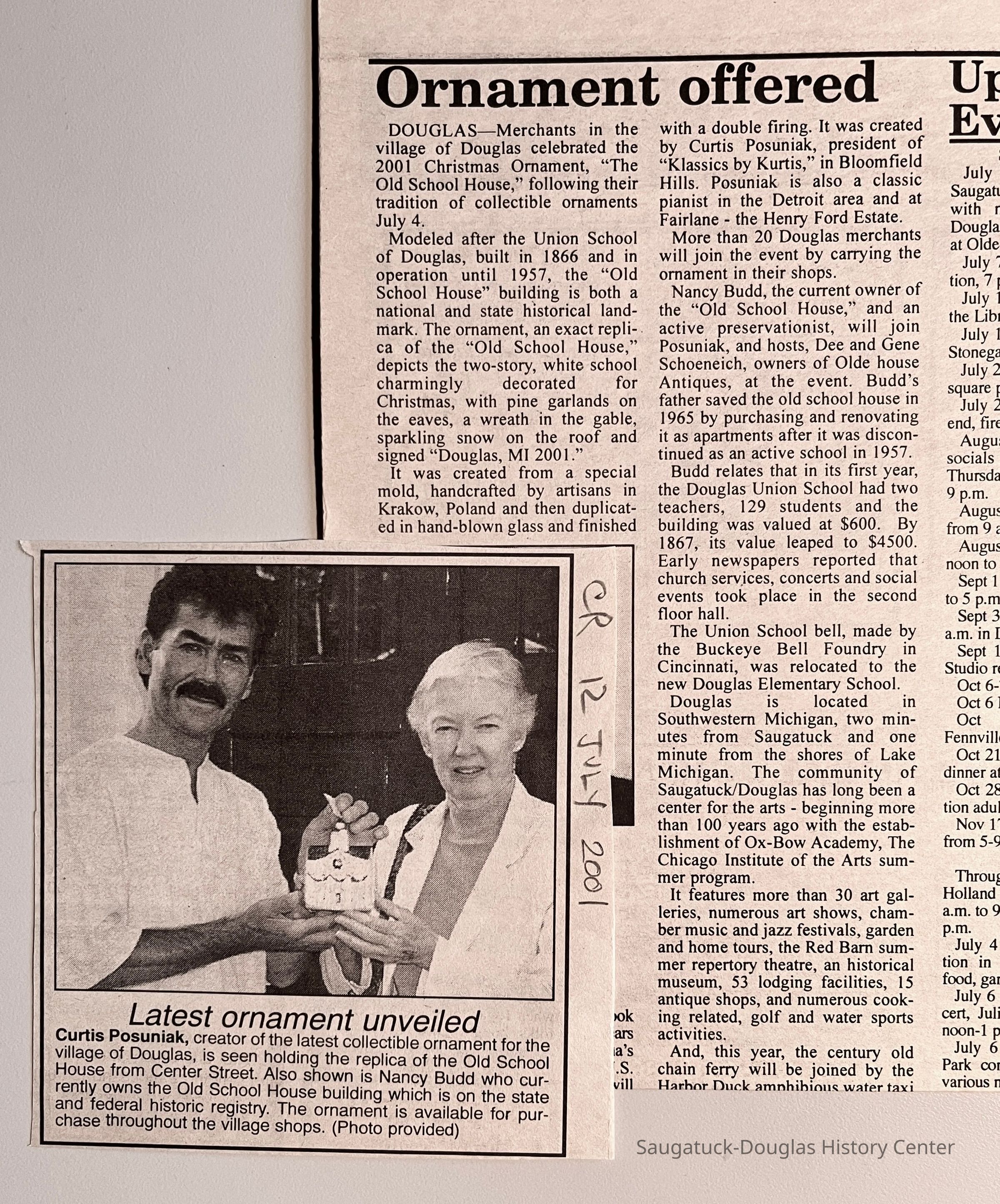 Curtis Posuniak, creator of the latest collectible ornament for the village of Douglas, is seen holding the replica of the Old School House from Center Street. Also shown is Nancy Budd who currently owns the Old School House building which is on the state and federal historic registry. The ornament is available for purchase throughout the village shops.
