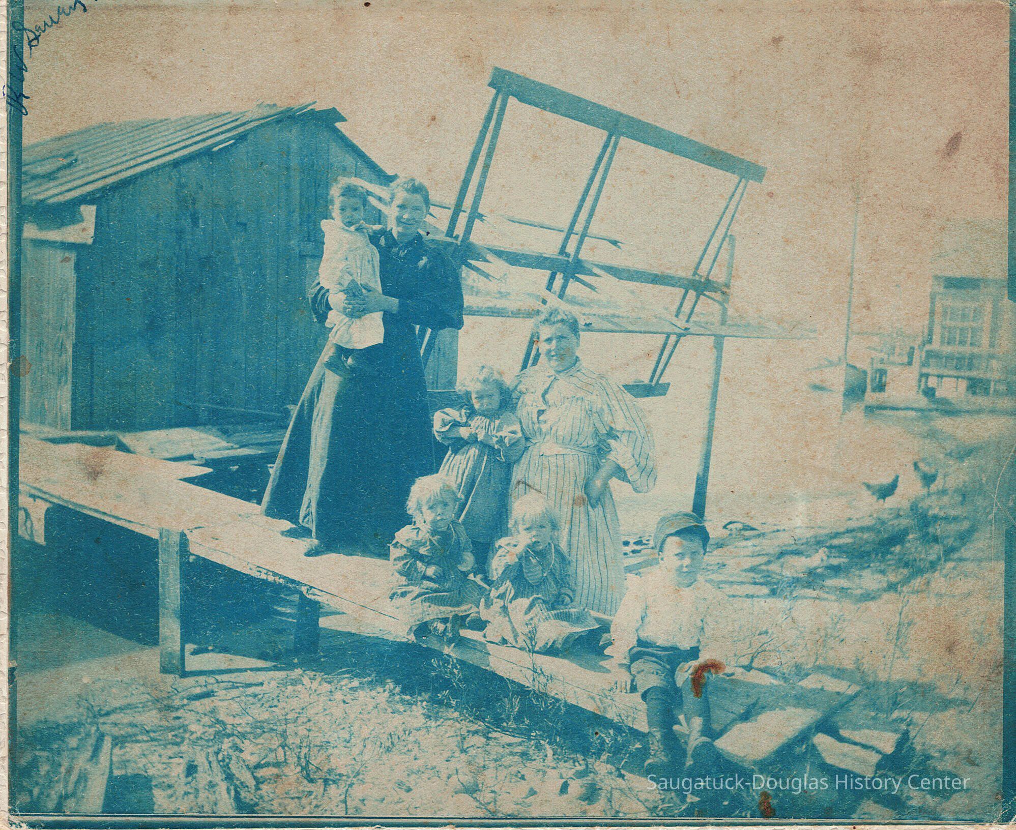 Mary Sewers and children, original cyanotype blue color; Mary Sewers (striped dress) with sons George (wearing cap), twins Frank and Rube (seated in gowns) and protesting daughter Florence. Standing woman in dark dress and baby is unknown.