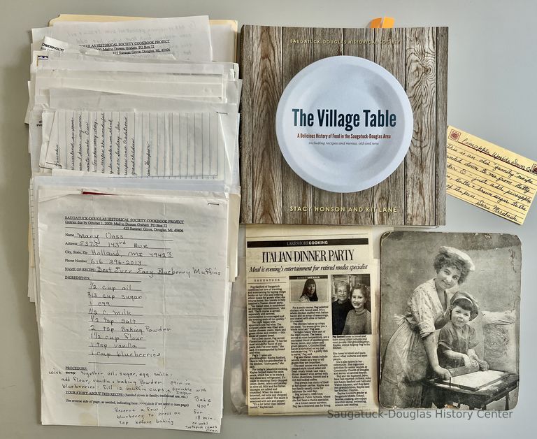          Member's recipe submissions, the finished book, the front of a fan provided by the A. Schmidt Home Bakery and an article about Peg Sanford's Italian Dinner Party recipes.
   