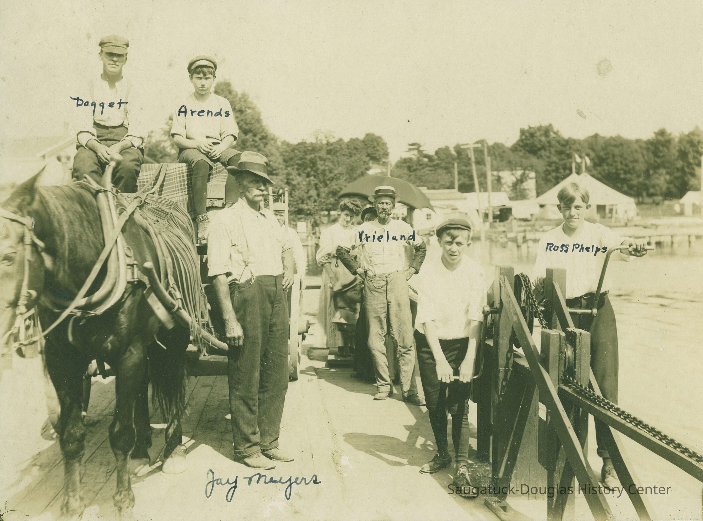          JayMeyersOnFerry.jpg 2.1MB; It's too bad we didn't have this picture when all the fuss was being made over the new Chain Ferry - because this is one of the best we've seen on the subject. This photograph was taken in 1907 and shows (left to right) Allie Daggett and Ivan Arends sitting up on the wagon. The ever popular Jay Myers is next with his famous pipe in place. The gentleman in the back with his hands on his hips is Mr. Vreeland. Russell Frehse has both hands on the crank handle, and is porting a brand new pair of knickers. Ross Phelps is on the outside crank. The ladies at the rear are not identified, but the horse's name was Dobbin, of course. [Caption text from an undated Commercial Record newspaper clipping]
   
