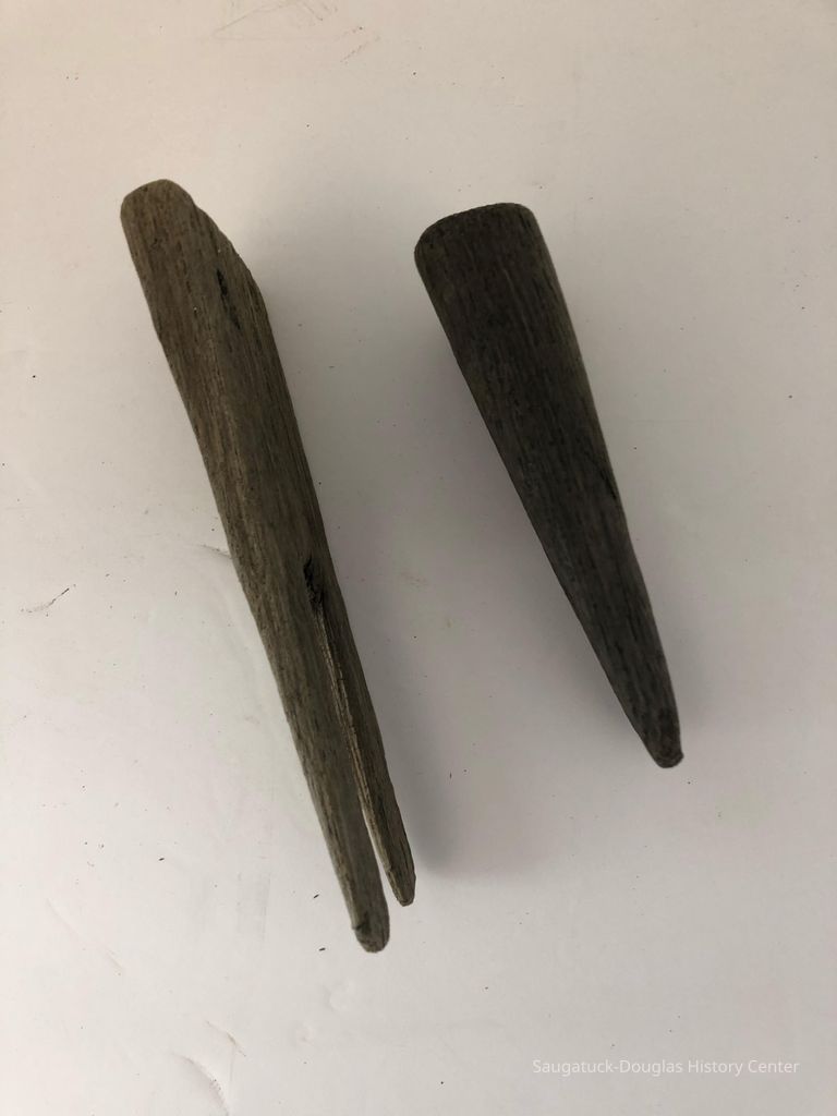 Side view of two hand carved 19 th century logging pins 