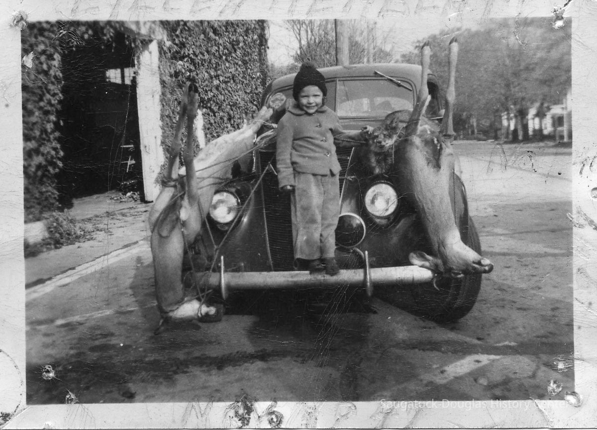 89-1-108 E. Herbert w deer.jpg 284KB; A child posing with two dead dear tied to the hood of a car