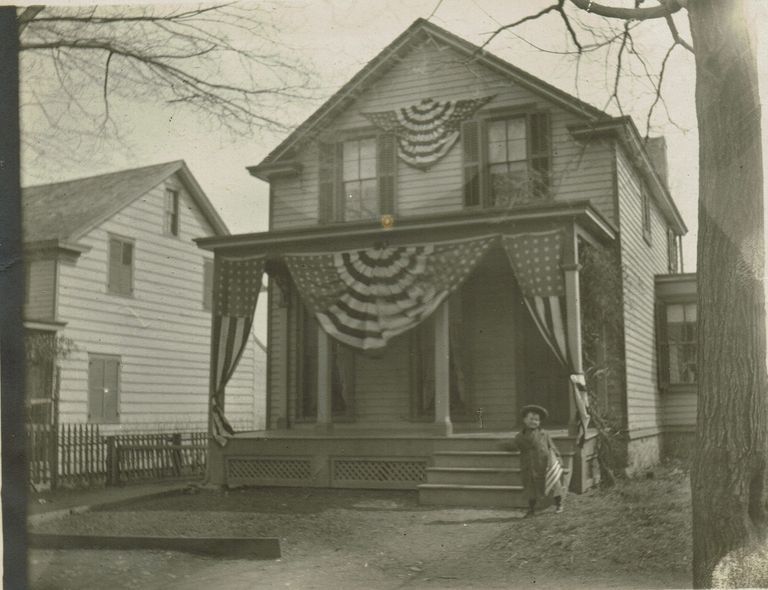          Marshall-Schmidt Album: Child With Flag in Front of House with Patriotic Bunting picture number 1
   