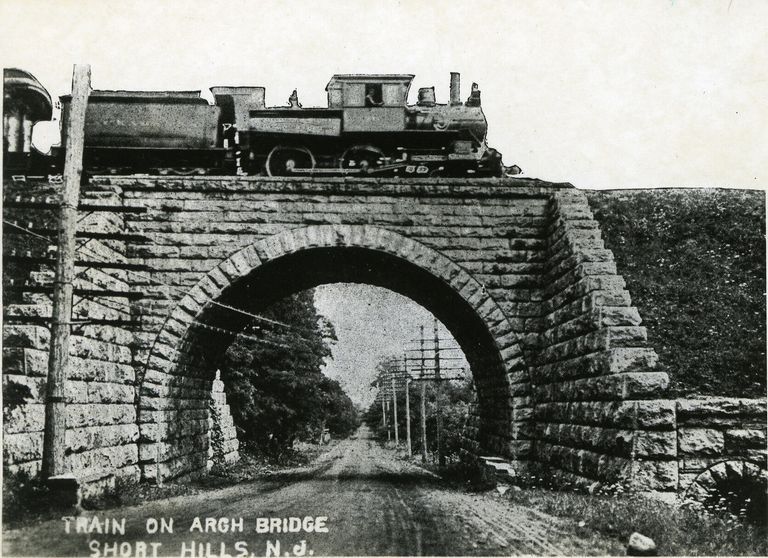          Camelback engine pulling passenger train over the new arch bridge.; Image Id# 151
   