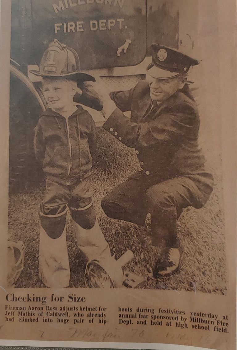          Fire Department: Photo of Fireman Aaron Ross adjusting helmet for Jeff Maths at Fire Department Annual Fair. picture number 1
   