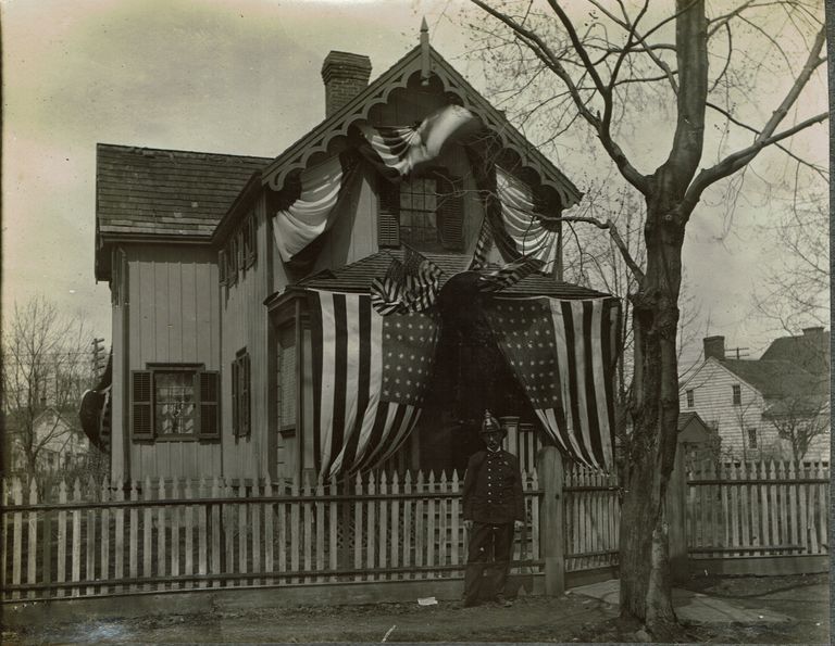          Marshall-Schmidt Album: Frank Marshall Standing Outside House Draped with Flags & Bunting picture number 1
   
