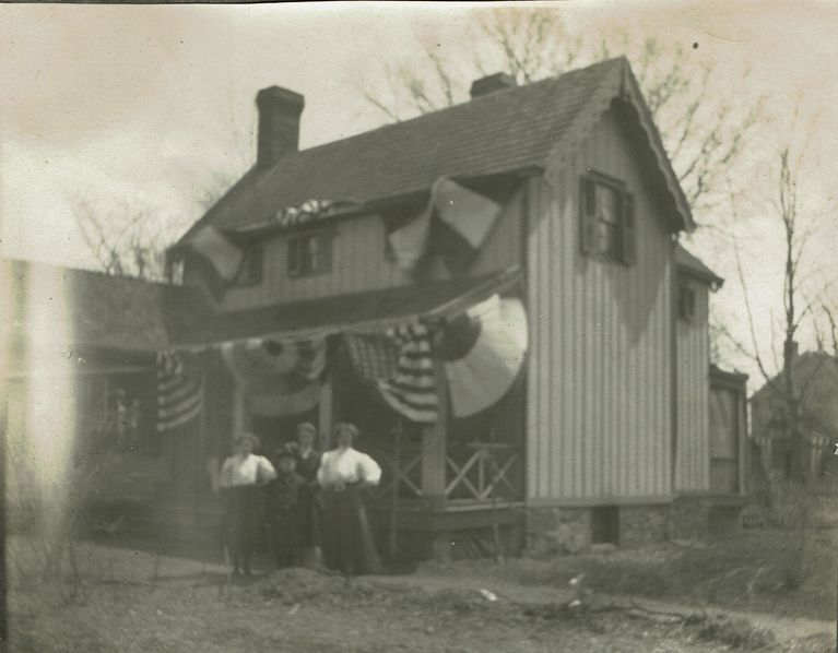          Marshall-Schmidt Album: Family Standing Outside Home Decorated with Bunting, c. 1907 picture number 1
   