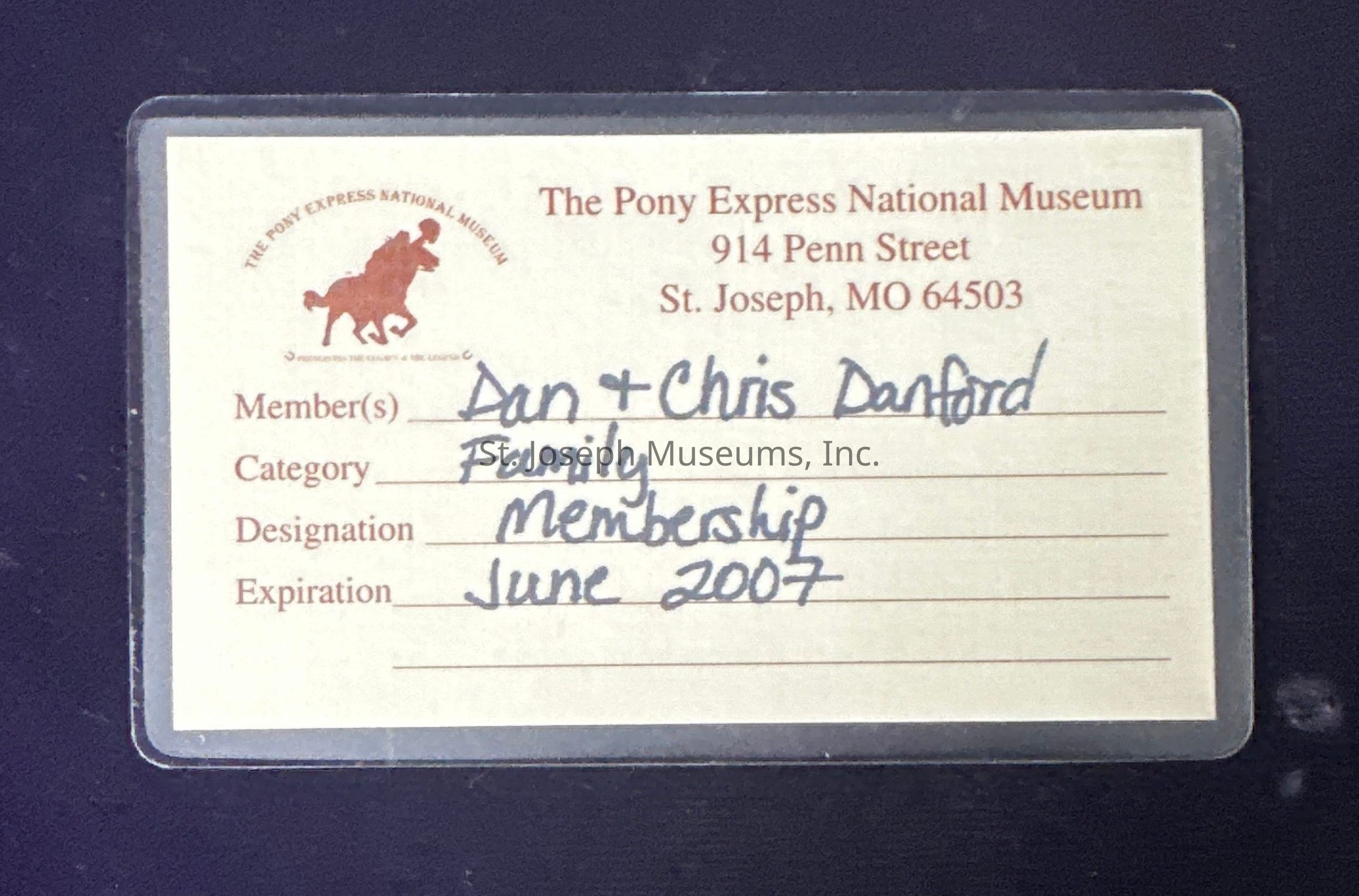 The image shows a membership card for the Pony Express National Museum, located at 914 Penn Street, St. Joseph, MO 64503. The card is issued to members Dan and Chris Danford under the family category, with a designation of membership. Notably, the membership's expiration date is listed as June 2007. The museum's emblem, a silhouette of a Pony Express rider on a horse, is printed in red on the card.