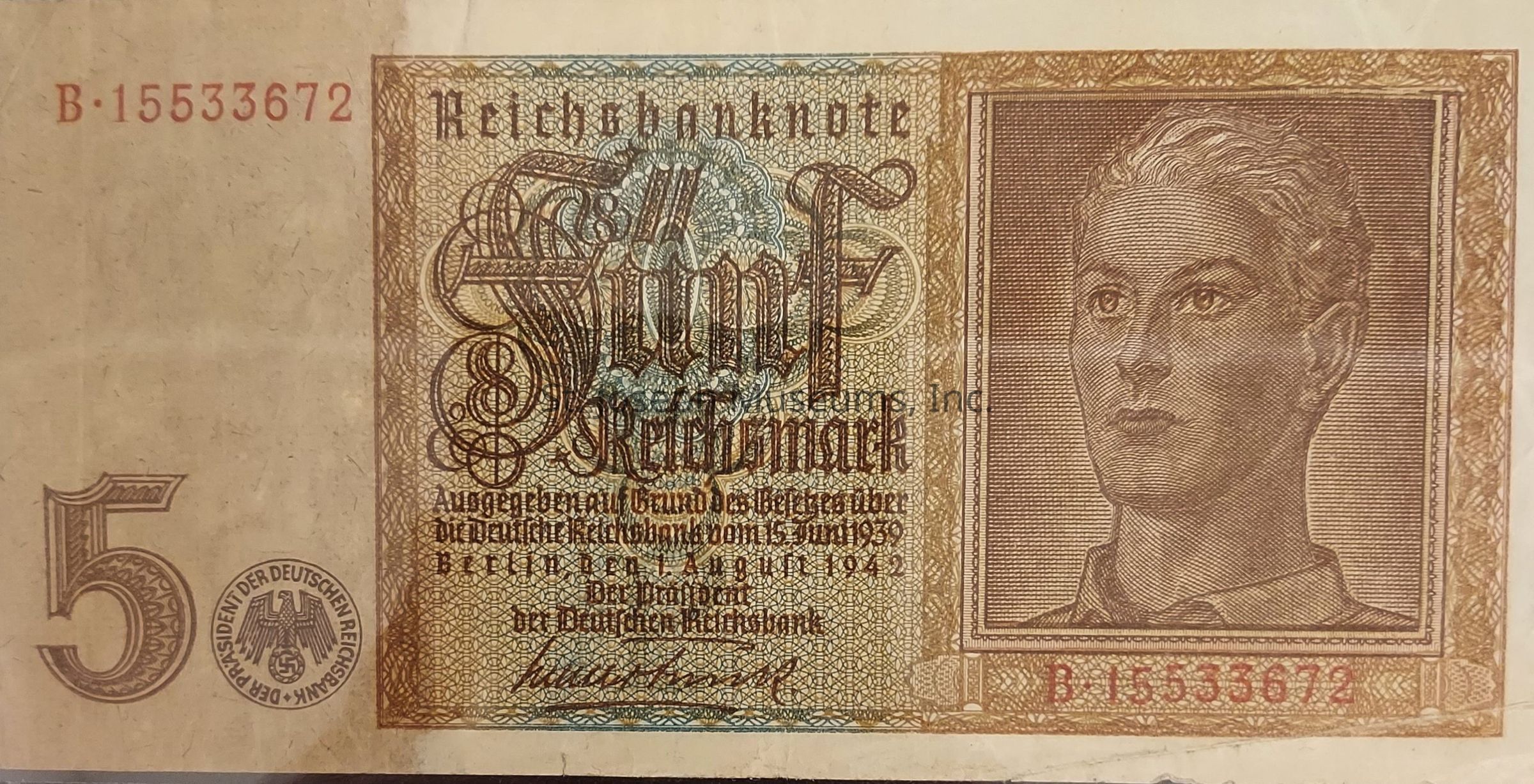 The image depicts a vintage 5 Reichsmark banknote from Germany, featuring intricate designs and inscriptions. On the right side, there is a detailed portrait of a person, framed with elaborate borders. The central text displays "Reichsbanknote" and "Fünf Reichsmark" in ornate typography. The left side shows the number "5" in a stylized font. Below the main design, there are additional inscriptions in German, providing details about the issuance of the note. Serial numbers "B.15533672" appear on both the top left and bottom right corners, indicating the note's unique identification.