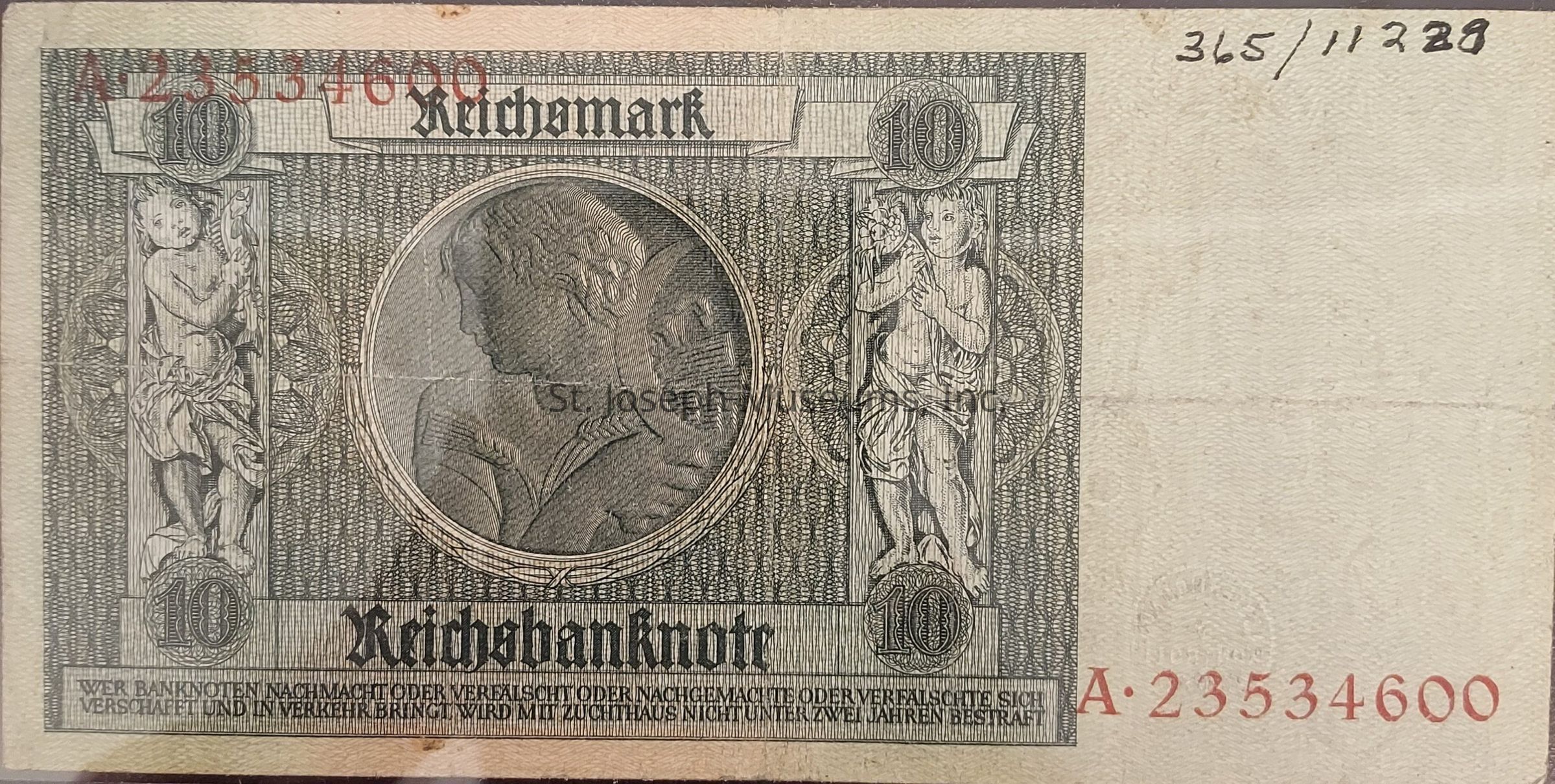 The image shows a vintage 10 Reichsmark banknote featuring intricate designs and engravings. In the center, there's a large circular engraving of a man in profile, surrounded by an elaborate pattern. On the left and right sides of the note, two cherubic figures are depicted holding symbols, framed by ornate designs. The denomination "10" is prominently displayed in each upper corner within a circle. The text "Reichsbanknote" is printed at the top and the bottom. A serial number, "A-23534600," is printed in red at the lower right, while additional numbers and text provide further details, possibly related to the note's issuance or security measures. The banknote’s overall design is complex and detailed, with fine line work and patterns.