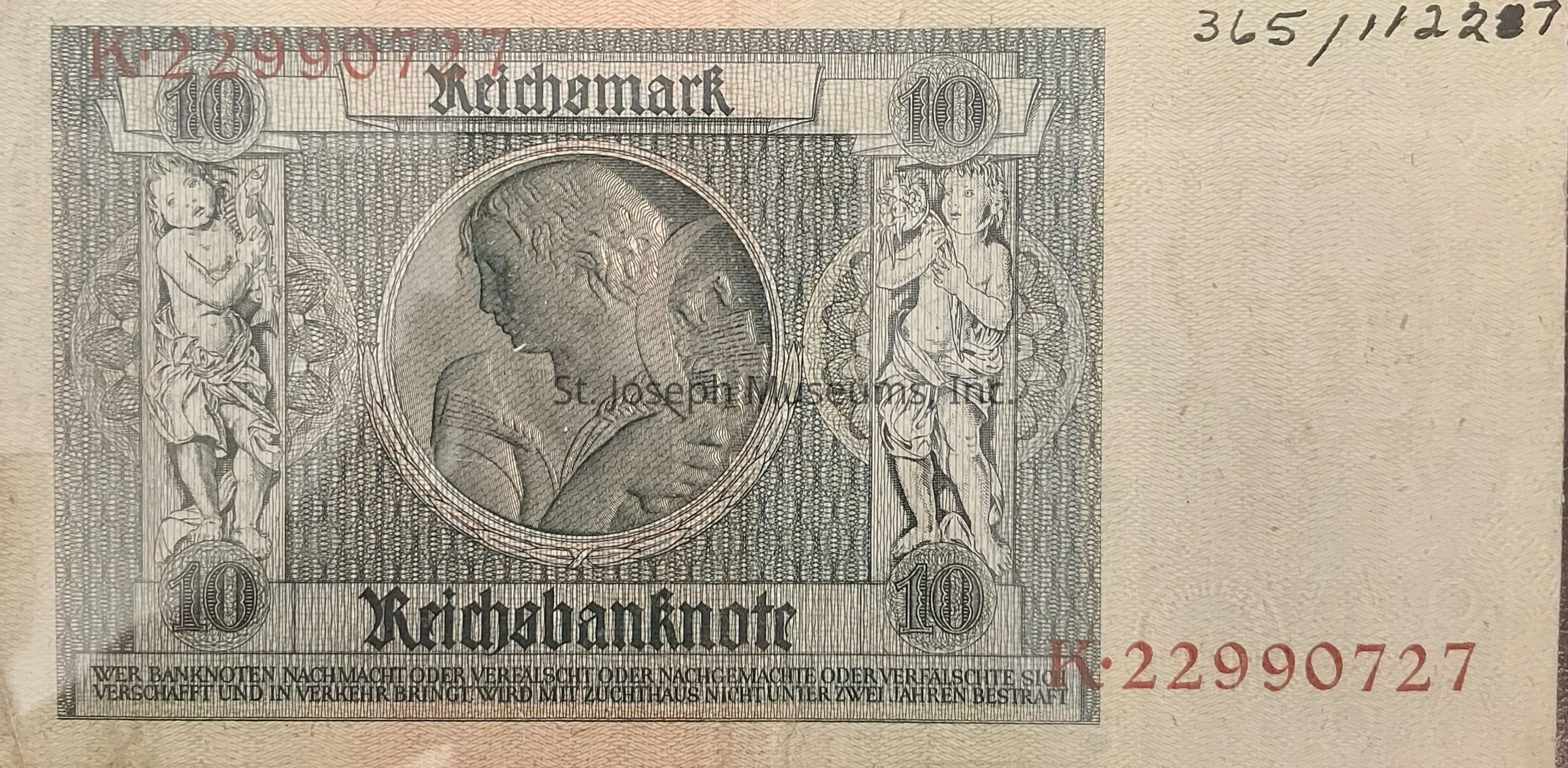 The image depicts a vintage German 10 Reichsmark banknote, featuring intricate design elements typical of early 20th-century currency. The note prominently displays "Reichsbanknote" at the bottom, with the denomination "10" printed on both sides of the central circular portrait of a woman. The background consists of detailed patterns, enhancing the banknote's artistic value. The right side contains the serial number "K-22990727" in red ink, adding to its authenticity. German text runs across the bottom, likely warning against counterfeiting. Overall, the note reflects historical monetary aesthetics, combining both security features and artistic flourishes typical of the era in which it was produced.