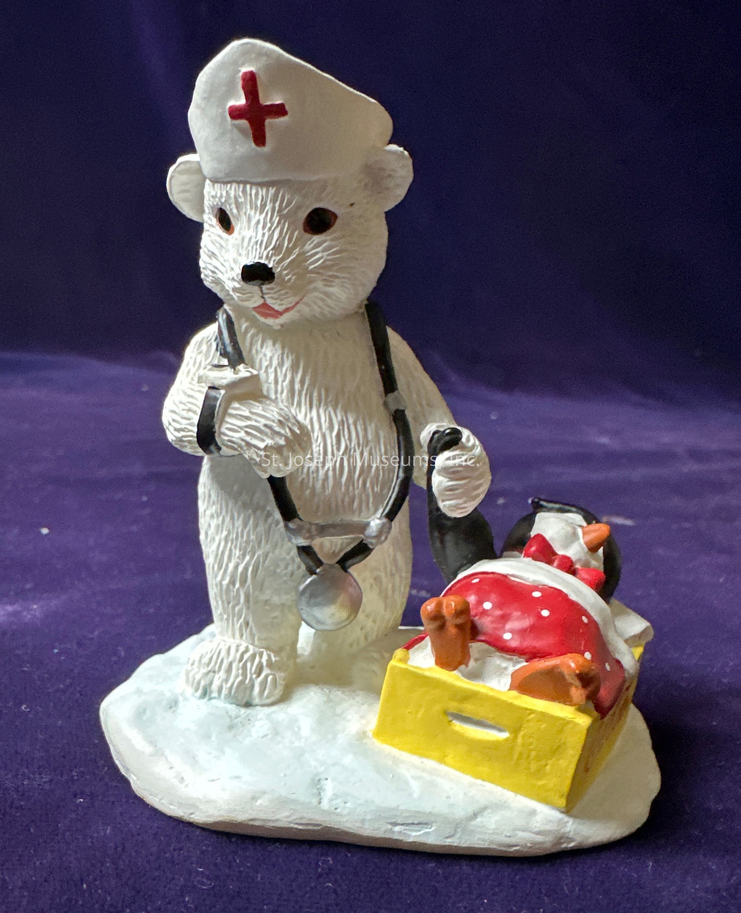 The image depicts a whimsical figurine scene featuring a polar bear dressed as a nurse, wearing a white nurse's hat with a red cross emblem, and a black stethoscope around its neck. The polar bear stands on a snowy base with a caring expression, suggesting its readiness to attend to a patient. Beside the bear, a penguin is cozily tucked in a yellow sled, lying on its back with its feet sticking out and wearing a red and white polka dot scarf that adds a touch of color and warmth to the scene. The creative and playful representation of these arctic animals in a medical setting creates an endearing tableau that conveys nurturing and care. The background is a rich purple, which contrasts with the white of the snow and bear, emphasizing the figures. This charming composition captures a sense of storytelling, warmth, and compassion, promoting an imaginative and heartwarming perspective on care and kindness in the animal kingdom.