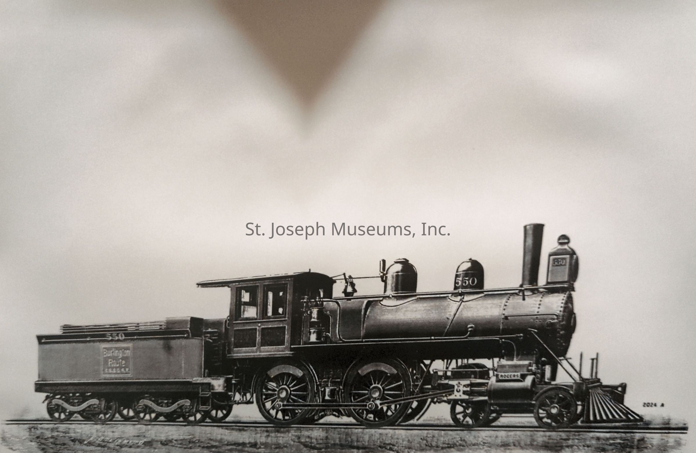 Black-and-white image depicting a detailed drawing of a Burlington Route locomotive, showcasing its intricate design elements in a realistic style. The steam engine features large wheels, a prominent smokestack, and clearly labeled parts, emphasizing its historical and mechanical significance. The tender is seen attached, branded with "Burlington" logo.