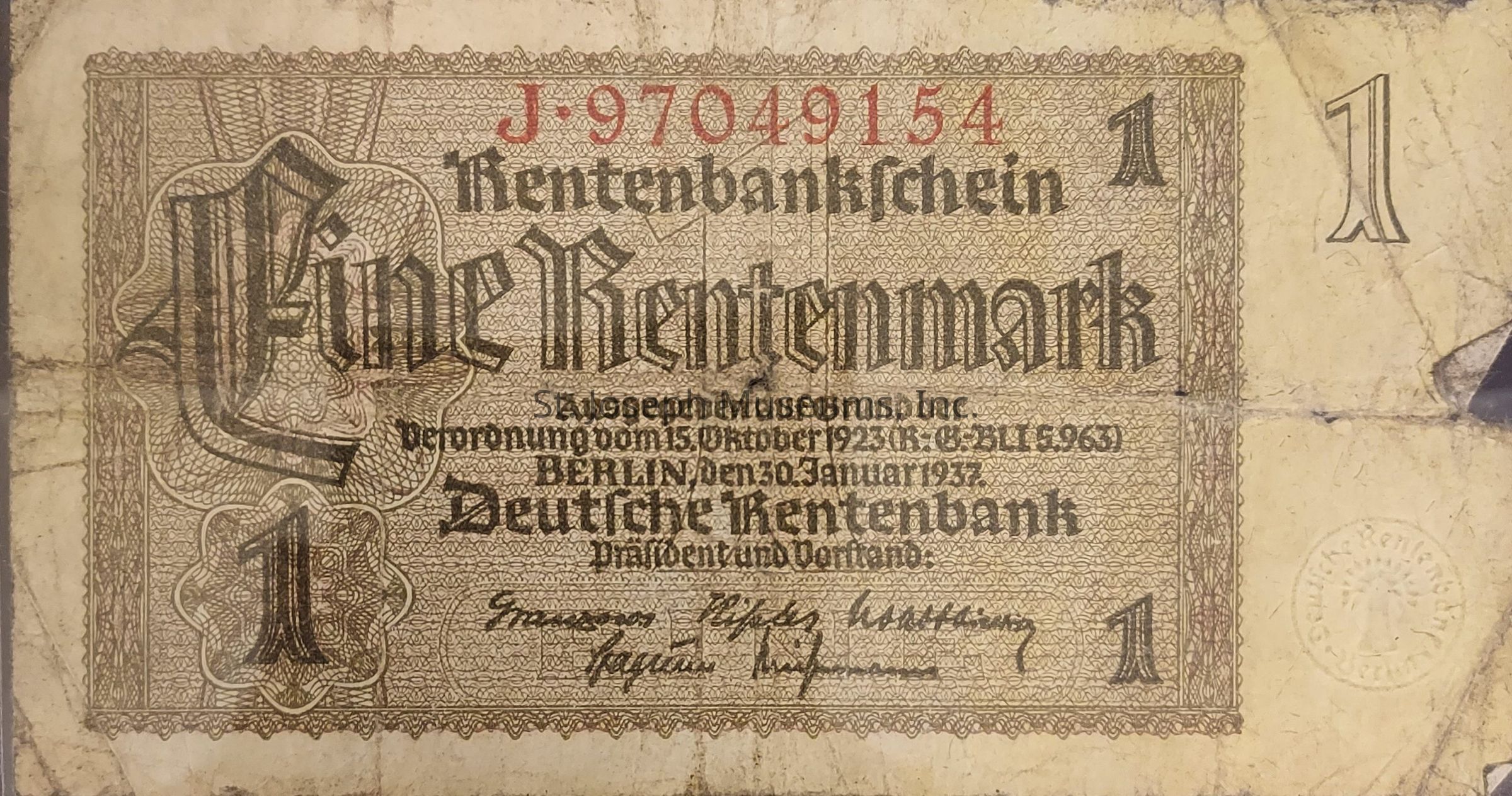 The image shows an old German banknote featuring the denomination of “Eine Rentenmark” prominently displayed in an elaborate Gothic script. It includes intricate patterns and a serial number in red at the top, "J-97049154." The note is issued by the Deutsche Rentenbank, with the text and signatures indicating it was released on January 30, 1937, in Berlin. The design is bordered with detailed filigree, and numbers "1" are positioned in the corners. The note appears worn, with visible creases and signs of age. A round stamp with "Deutsch Rentenbank" is faintly visible on the right side, adding authenticity.