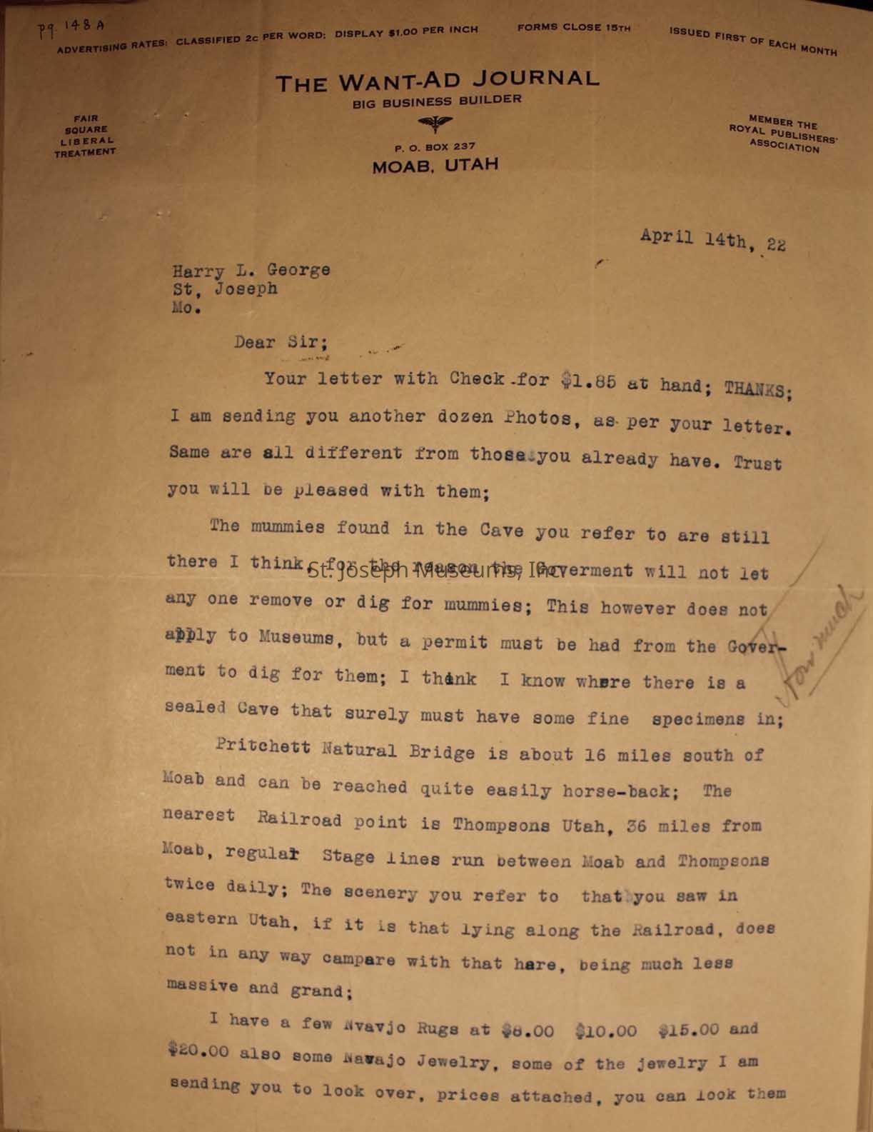 The image shows a typed letter on stationery from "The Want-Ad Journal" in Moab, Utah. The letter acknowledges his previous letter and enclosed check for $1.85 check and mentions the sender is providing another dozen photos different from those previously sent. It discusses the presence of mummies in a cave, explaining that government restrictions prevent their removal without a museum permit. The letter also mentions the Pritchett Natural Bridge near Moab, accessible only by horseback and briefly discusses the local scenery. Additionally, it describes Navajo rugs and jewelry available for sale, encouraging Mr. George to review the attached price list.
The letter continues on the second page to advising Mr.George he can review the items and decide which ones to keep, requesting a check for those he wishes to purchase and asking for the return of others. The note mentions that photos and silverware are under separate cover, suggesting that those items require particular attention or handling.