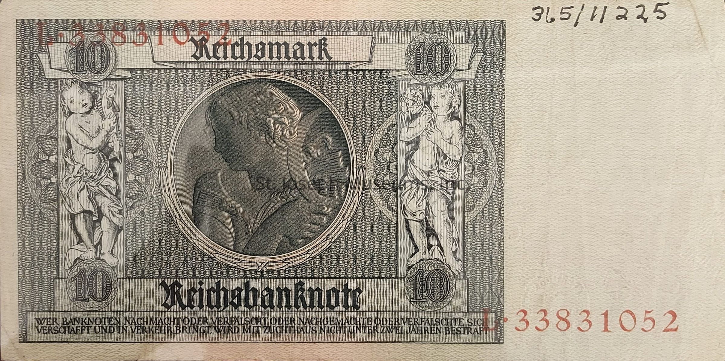 The image shows a historical banknote featuring the denomination of 10 Reichsmark. The design is intricate, showcasing a central oval portrait with two cherubic figures on either side, each holding a decorative floral or ornate element against a densely patterned background. The top section prominently displays "Reichmark" while the bottom reads "Reichsbanknote" in bold Gothic script. The corners have circular designs indicating the number 10, and the edges bear serial numbers in red ink. The overall aesthetic reflects the ornate and symmetrical style typical of the early 20th century currency.