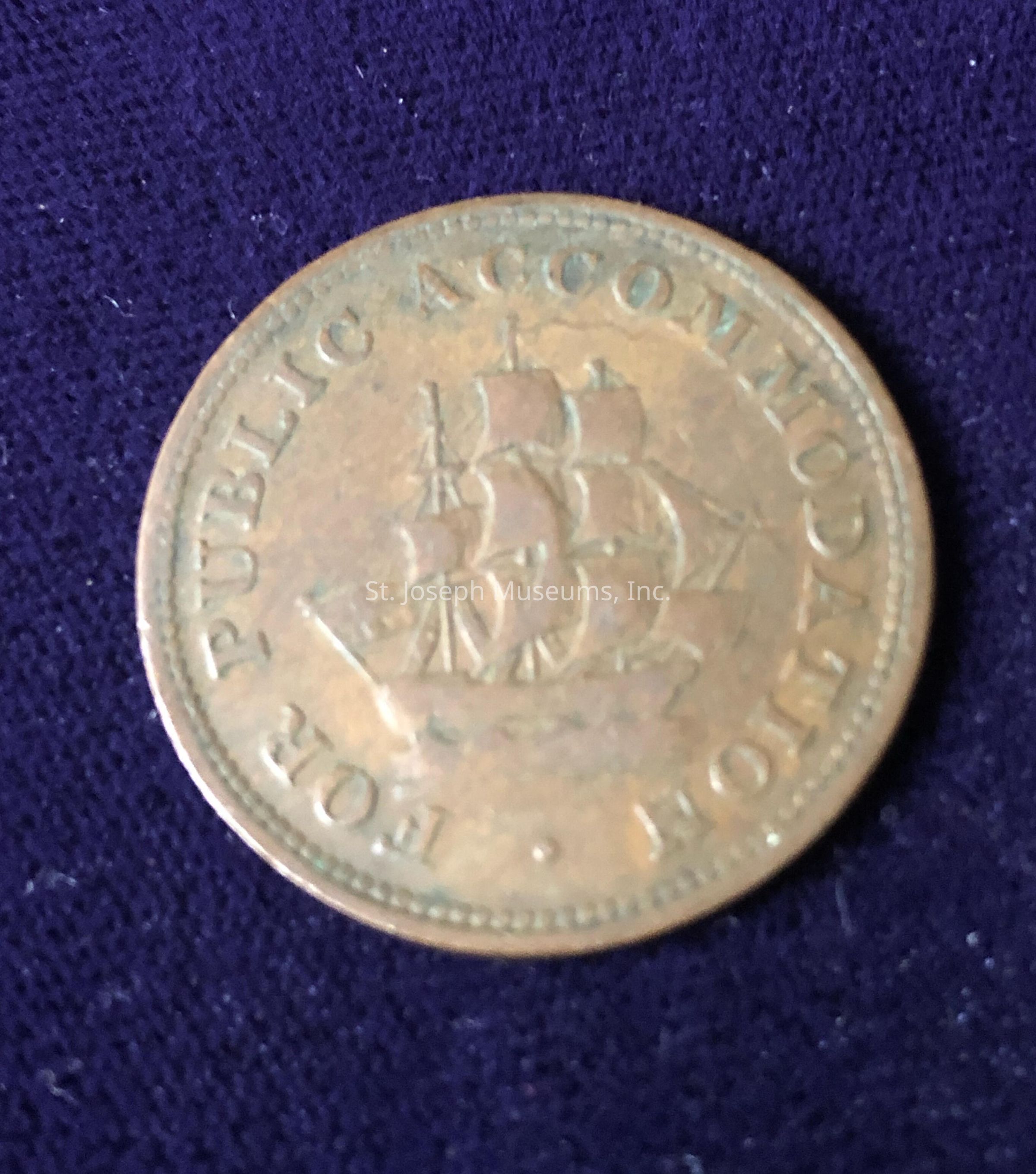 The coin's surface has a bronze hue with a slightly worn appearance, suggesting age and usage over time. In the center of the coin, there is an intricate engraving of a sailing ship with multiple sails unfurled, suggesting a design that might be from the age of sailing exploration or trade. Surrounding the central image, along the coin's edge, are embossed words that appear to read, "FOR PUBLIC ACCOMMODATION," though some letters might be partially obscured or faded. The edge of the coin is finely ridged, providing a border to the detailed artwork within. The overall condition of the coin, including minor imperfections and patina, might indicate it is a historical or collectible piece, possibly used for trade or commemorative purposes. The artistic depiction of the ship and the phrase suggest a theme of public service or cooperation, reflective of its origin or function.