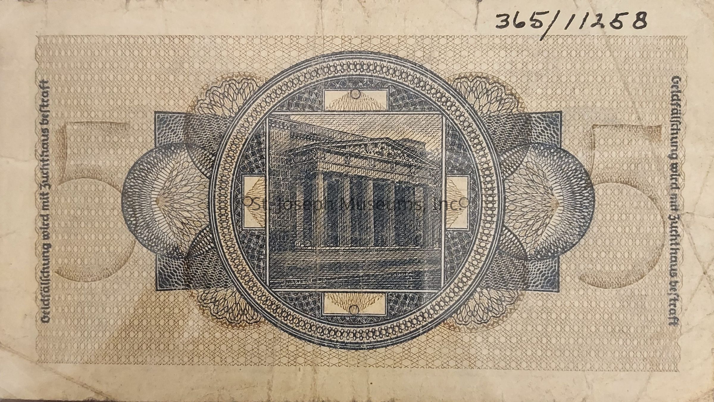 The image showcases an old banknote featuring intricate design elements predominately in shades of beige and blue. In the center, there's an elaborate circular pattern with a depiction of a classical building that resembles ancient Greek or Roman architecture, likely a temple with columns and a triangular pediment. The surrounding design is composed of complex geometric patterns and fine lines, contributing to the detailed security features typical of currency. The texture of the paper suggests age, with visible creases and slight discoloration, typical of vintage currency, and the number "5" subtly integrated into the design indicates its denomination.