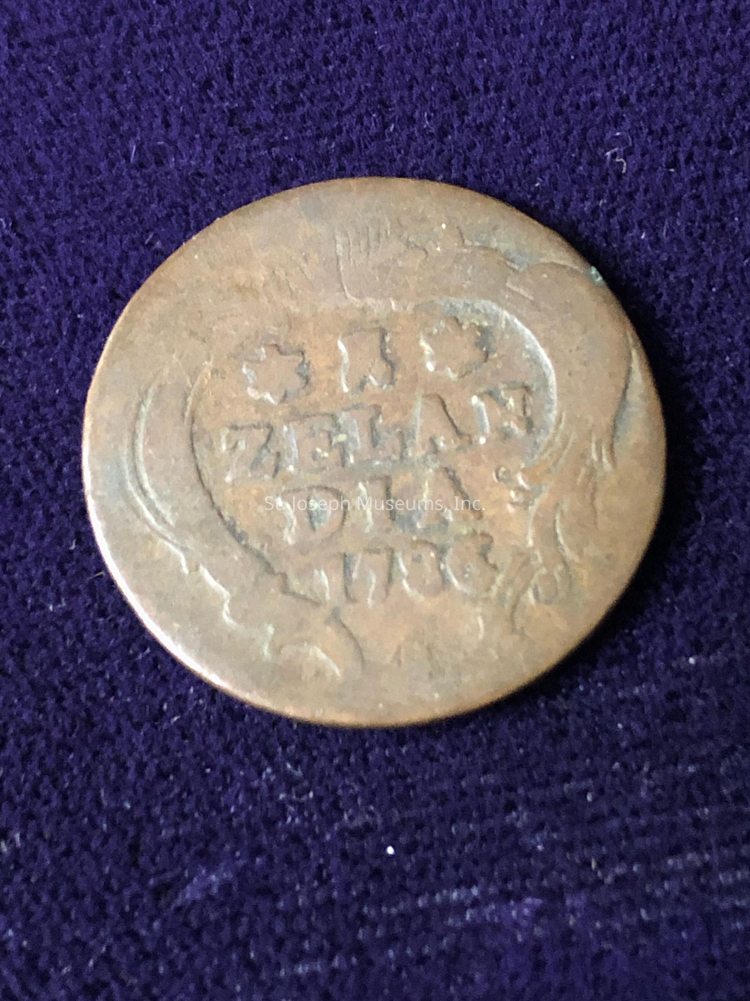 Showing signs of aging and wear, which can be noted from its tarnished surface and slightly worn inscriptions; on the coin, the words "ZELANDIA 1790" and some decorative elements such as stars are faintly visible, suggesting it might be an antique piece from the late 18th century, potentially originating from a historical production batch related to the geographical area indicated by the name on the coin, offering an intriguing glimpse into monetary history and the stylistic designs used in numismatics during that era.