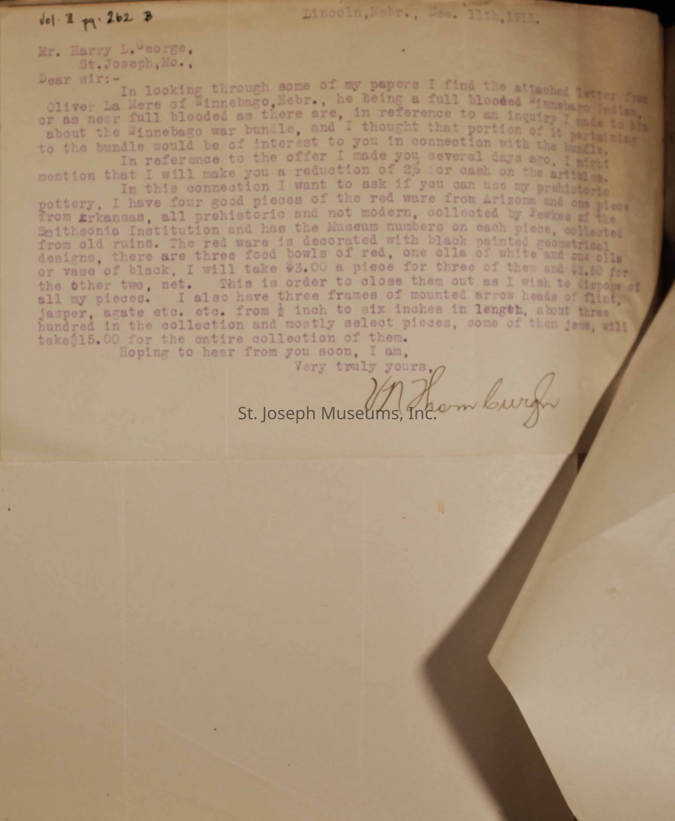The image displays a typed letter dated December 11, 1915, addressed to Mr. Harry L. George in St. Joseph, Missouri, from a correspondent in Lincoln, Nebraska. The letter discusses artifacts and pottery, mentioning an offer of a reduction in price for certain items and expressing interest in selling four pieces of red war pottery from Arizona.
