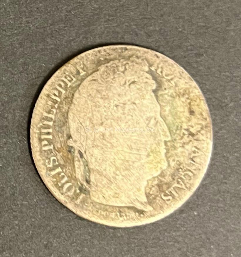 The image displays an old, weathered coin placed against a dark, textured background, likely made of metal with signs of wear such as scratches and patina, which suggests its antiquity and possible historical significance. The coin features a profile of a person in relief on one side, facing right, surrounded by Latin script that reads "JOSEPH II D G R I S A G FRANCIS." The detailed engraving accents the features of the individual's profile, although the edges show some wear, which may indicate extensive handling or circulation over time. Overall, the coin presents an intriguing glimpse into historical currency, offering a tangible connection to the past and hinting at the rich stories and transactions it may have been part of.